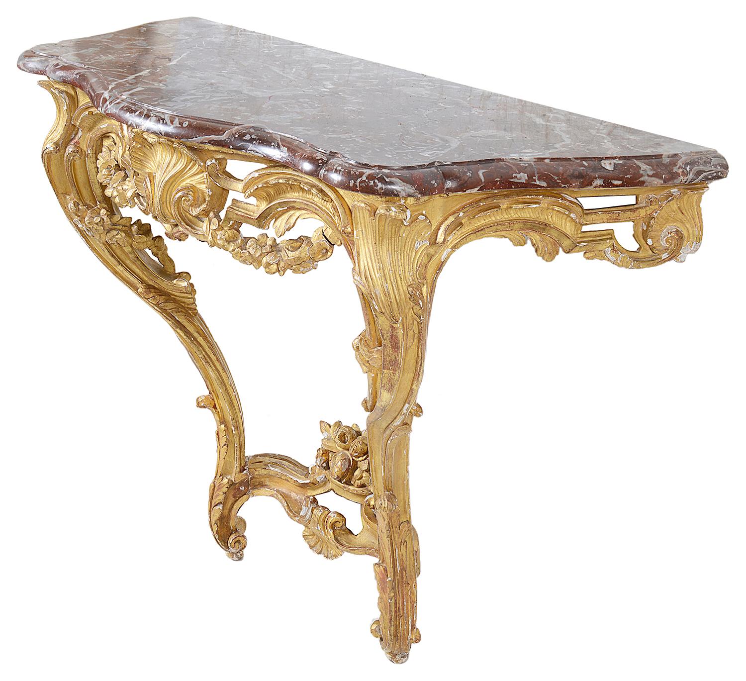 Une table console de bonne qualité en bois doré sculpté du 18ème siècle, avec une décoration de feuillage en C, une coquille centrale à la frise, des pieds cabriole sculptés, unis par une civière en dessous.