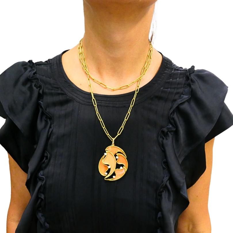 Questo sorprendente ciondolo francese vintage è realizzato in 18 ct.  in oro, mostrando curve scultoree e audaci di corallo incorniciate da bordi in oro lucido. Scintillanti diamanti a taglio rotondo sono incastonati con grazia lungo il design