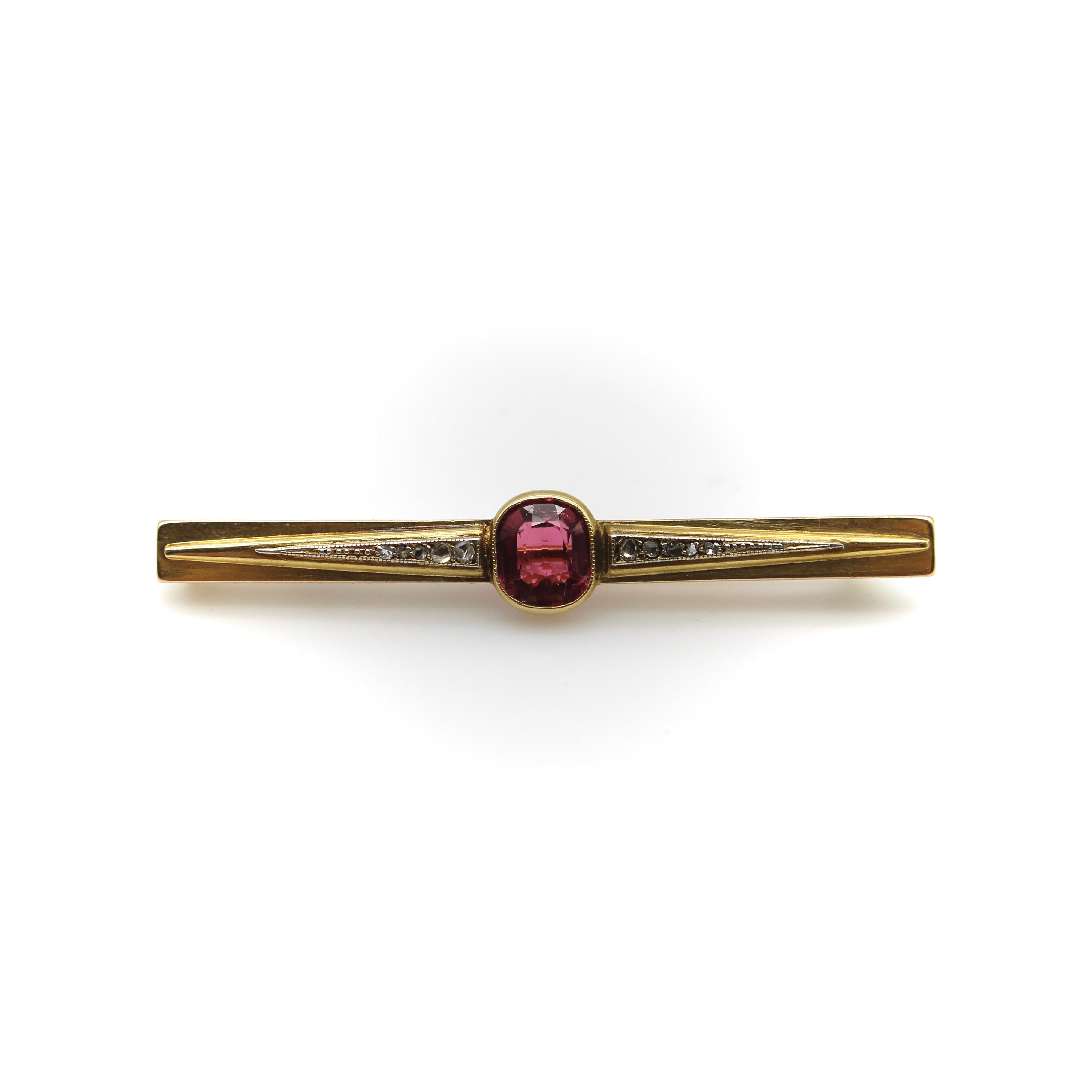 Circa 1870, cette magnifique broche française présente une tourmaline rose comme pièce maîtresse, flanquée de triangles cloutés de diamants Rose Cut le long d'une broche horizontale en or 18k. La tourmaline est de forme ovale et sertie d'un chaton -
