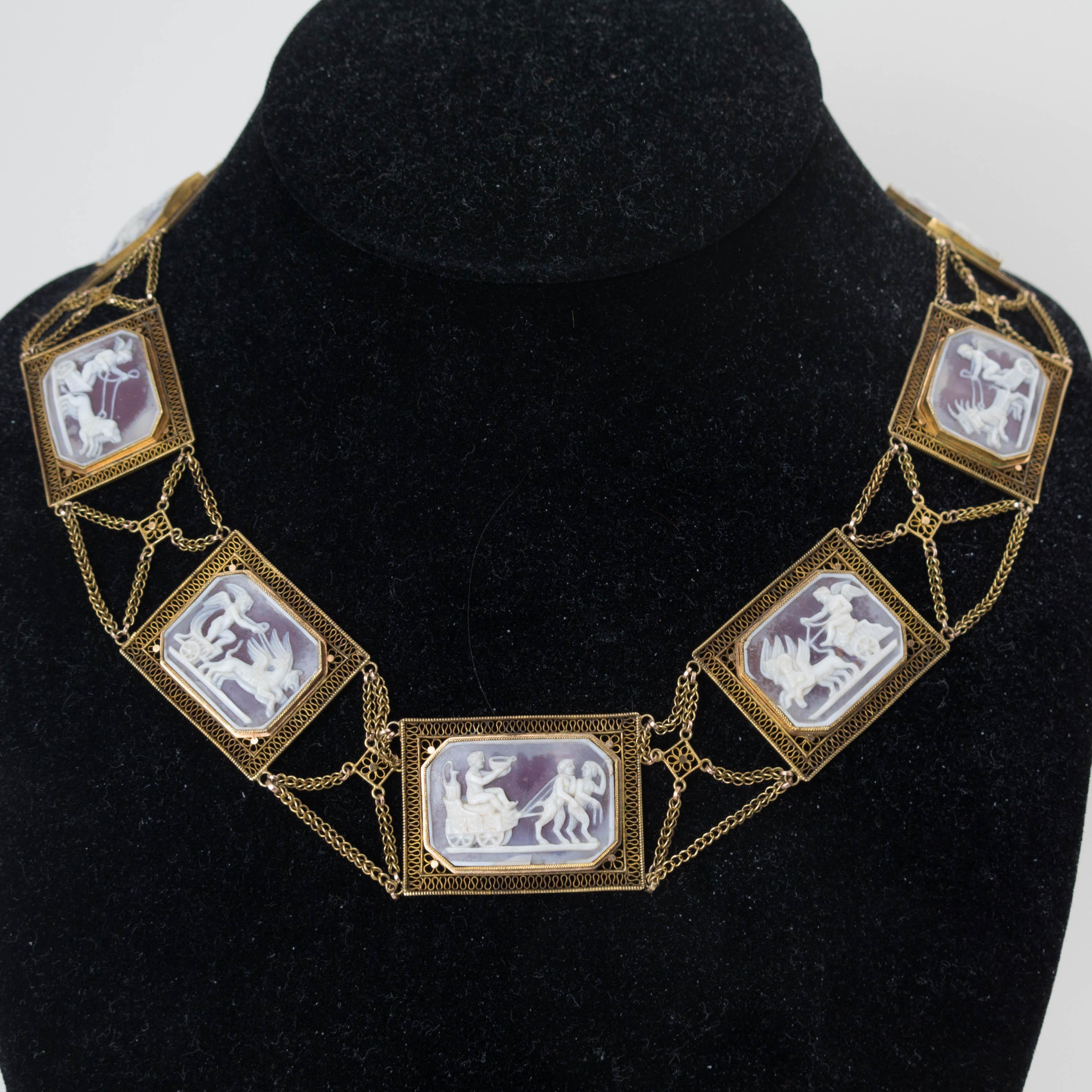 A rare early necklace of hardstone cameos panels depicting putti drawing chariots pulled by mythical beasts. Set in 18k gold. French circa 1805 - 1810. Total length :16”. 
Gross weight: 54.3 grams.