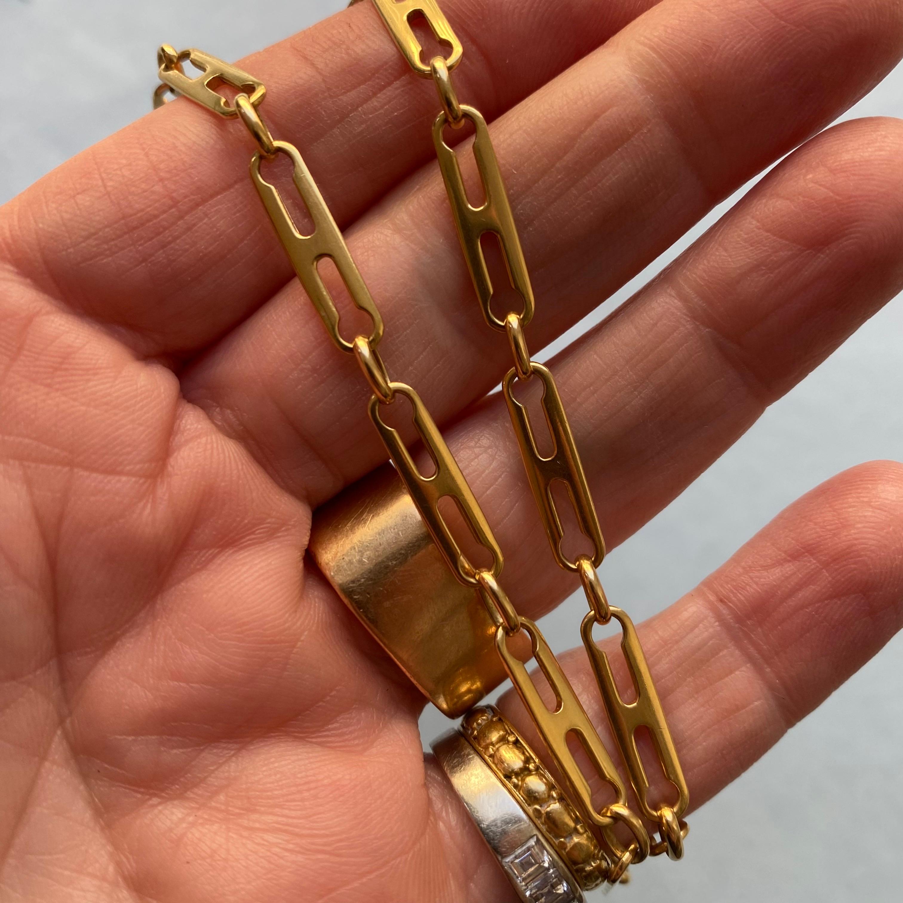 Una collana di graffette in oro giallo 18 carati con due buchi di serratura giustapposti nelle maglie,  circa 1970 con marchi di controllo francesi 
peso: 18,56 g 
lunghezza: 46 cm
larghezza: 4,5 mm