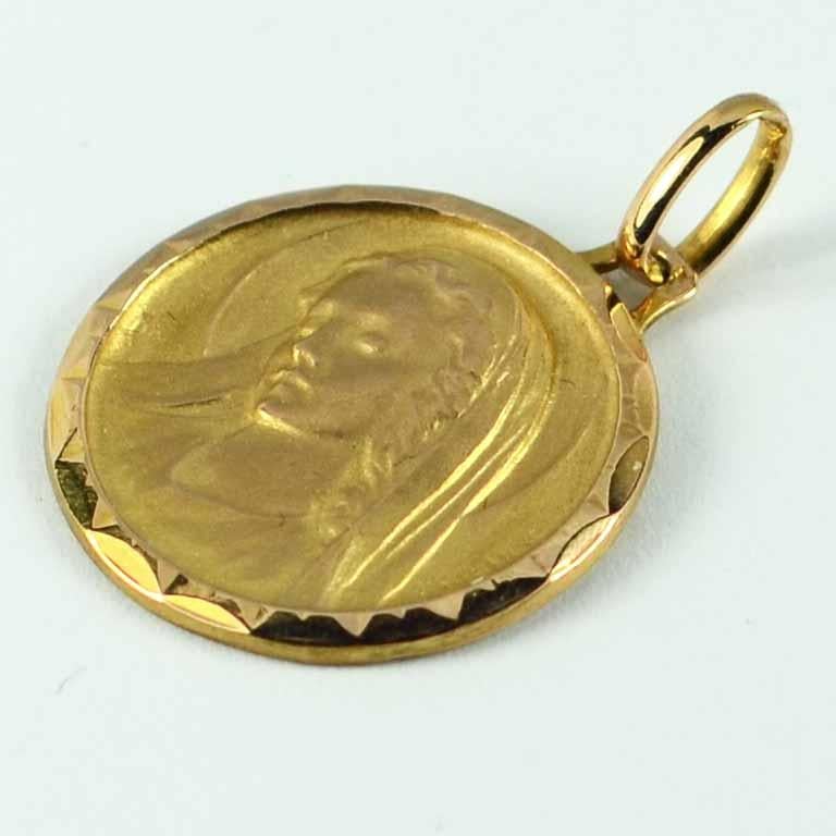 A French 18 karat (18K) rose gold charm pendant or medal designed by Monier depicting the three-quarter profile of a young female saint, presumably the Virgin Mary, surrounded by a faceted frame. Stamped with the eagles head for French manufacture,