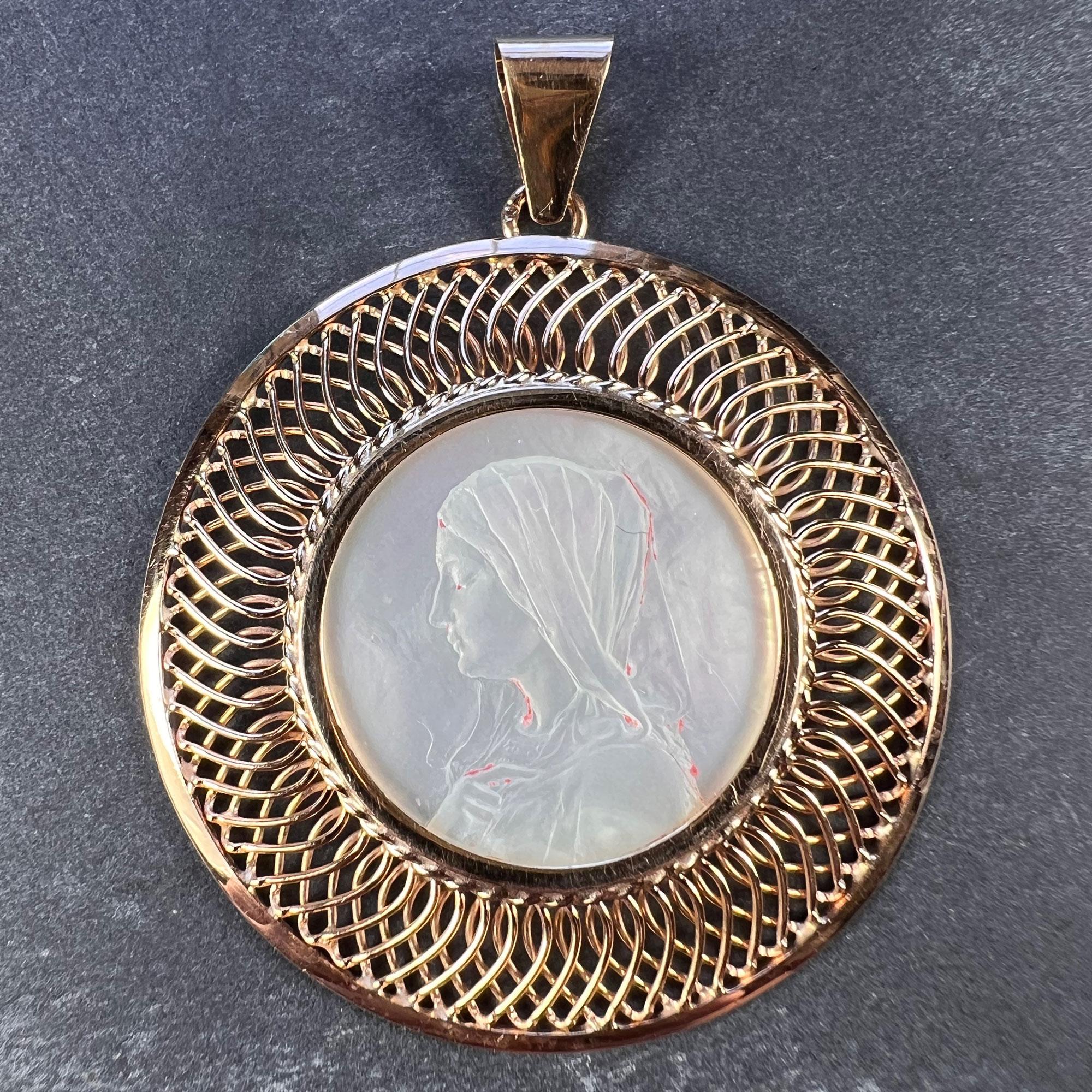 A French 18 karat (18K) rose gold charm pendant designed as an oval representing the Virgin Mary as a Mother-of-Pearl cameo set in a basketwork gold wire frame. Stamped with the eagles head for French manufacture and 18 karat gold.

Dimensions: 4.1