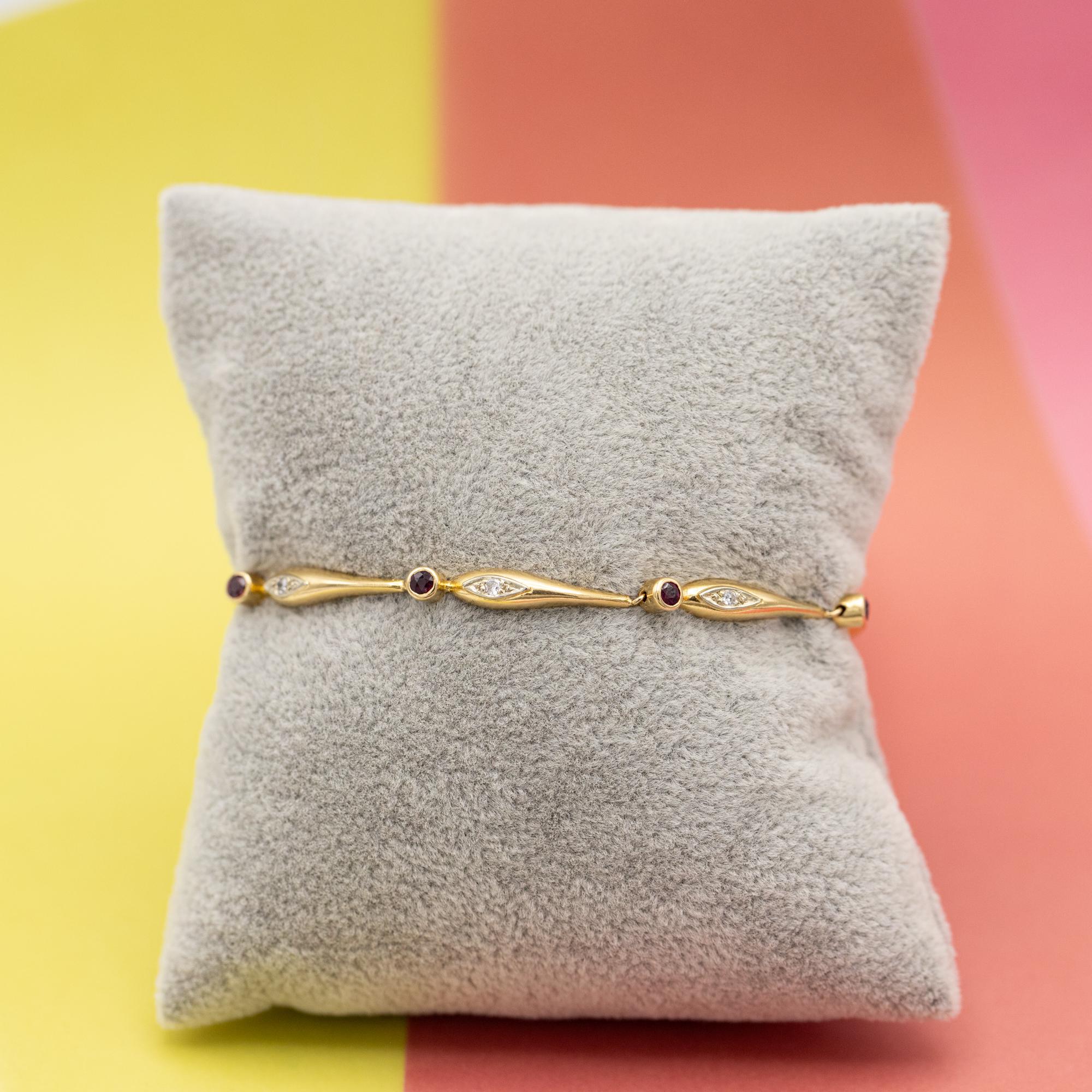 For sale is this French 1940's elegant gold bracelet set with diamonds and pinkish rubies. This tennis bracelet is decorated with brilliant cut, bezel set rubies which are alternating with diamond set in elegant drop shaped links. These small but