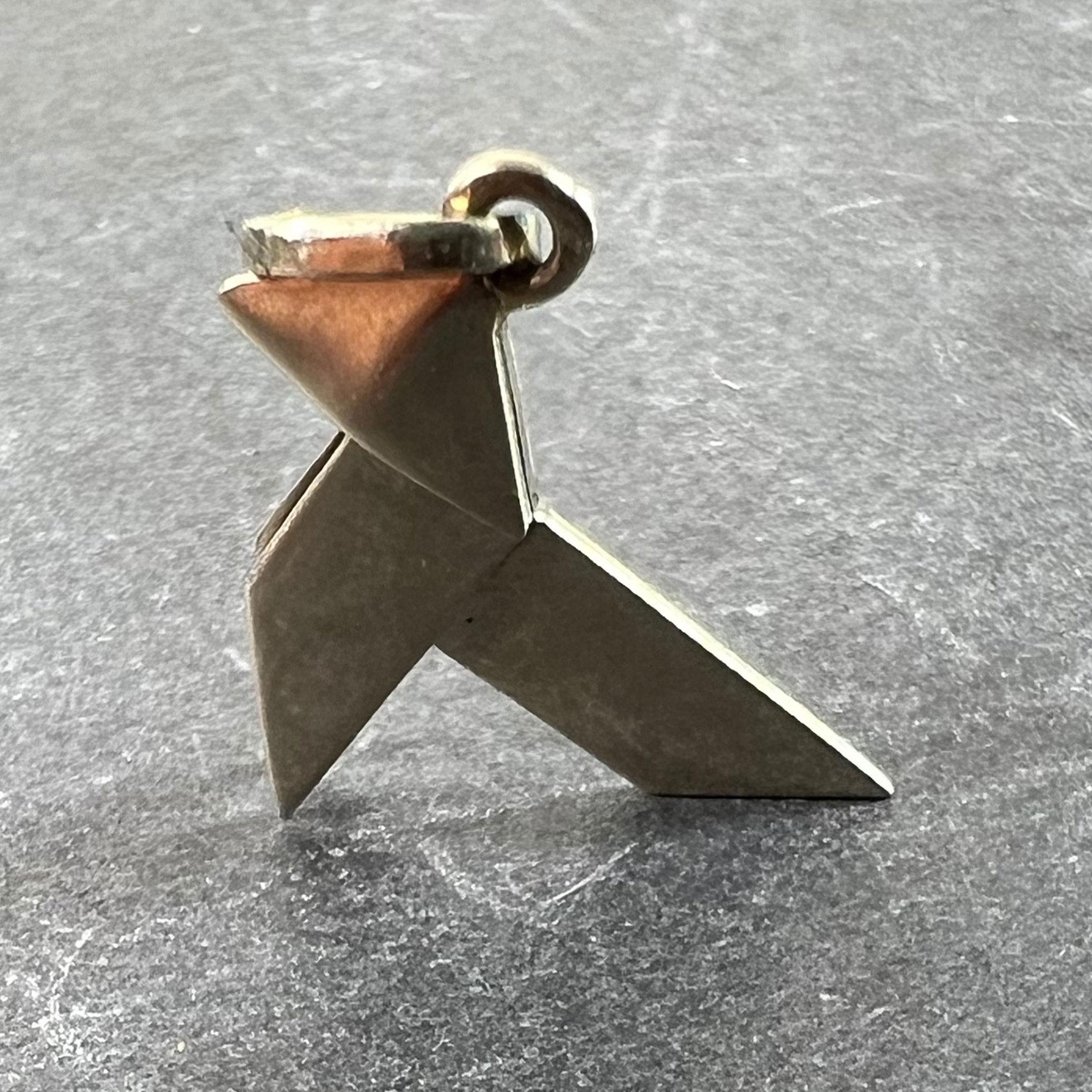 A French 18K (18 karat) white gold charm pendant designed as a folded Japanese origami bird. Stamped with the eagle's head poincon for 18 karat gold and French manufacture along with an unknown maker's mark.

Dimensions: 1.5 x 1.7 x 0.2 cm (not