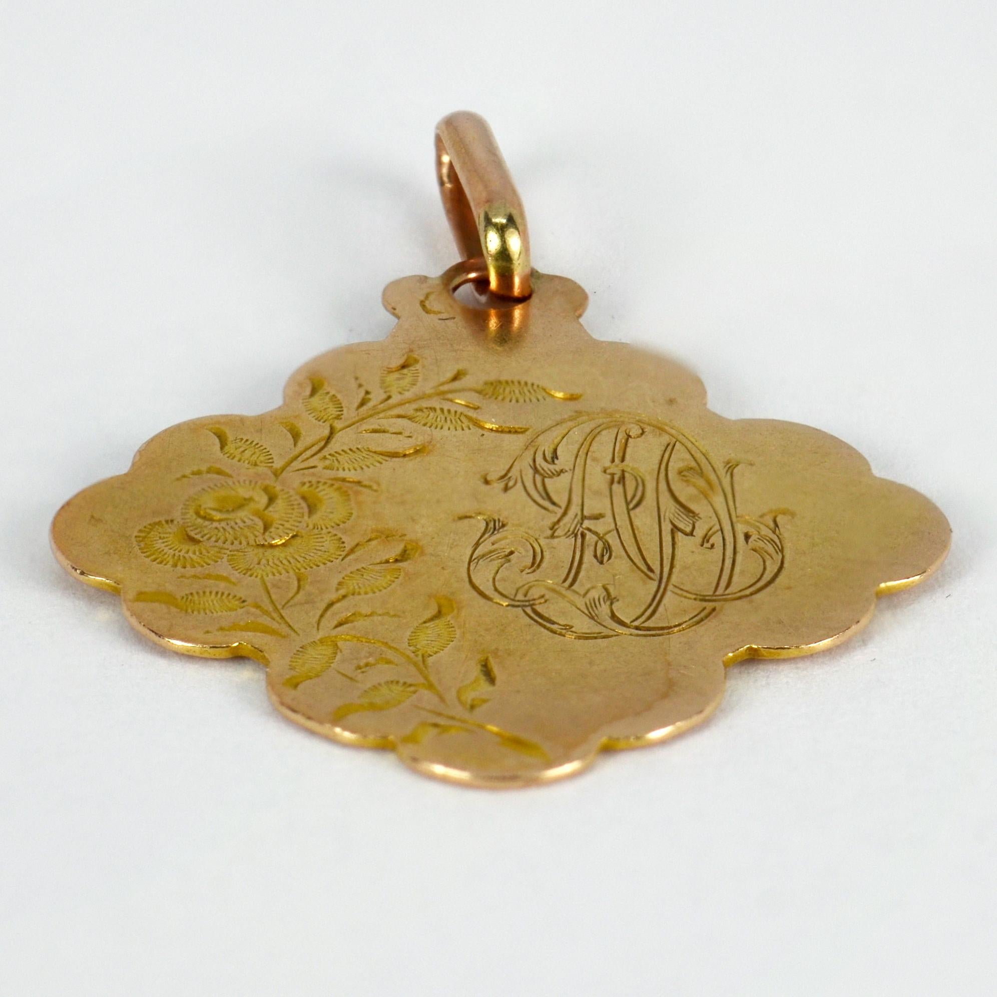 A French 18 karat (18K) yellow gold charm pendant designed as scalloped quatrefoil engraved with a rose and the monogram of the initials AD. Stamped with the eagle’s head for 18 karat gold and French manufacture.
 
Dimensions: 2.6 x 2.3 x 0.05 cm