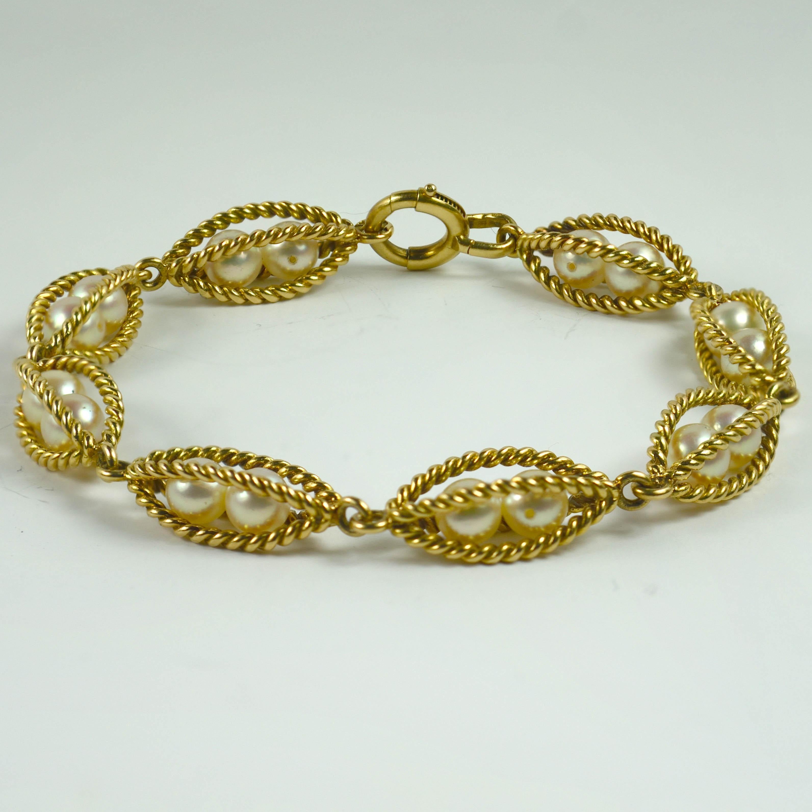An 18 karat yellow gold bracelet with cultured pearls caged by twisted gold wires. 
French marks for 18k gold and makers mark for Edouard Thuillier.

Weight: 22.10 grams
Dimensions: 8