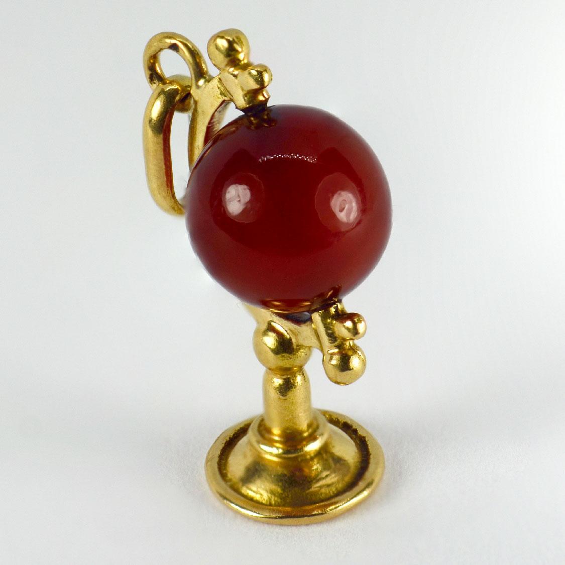 A French 18 karat (18K) yellow gold charm pendant designed as a spinning carnelian globe on a stand. Stamped with the eagles head for French manufacture and 18 karat gold with an unknown maker’s mark.

Dimensions: 2.2 x 1.5 x 0.9 cm (not including