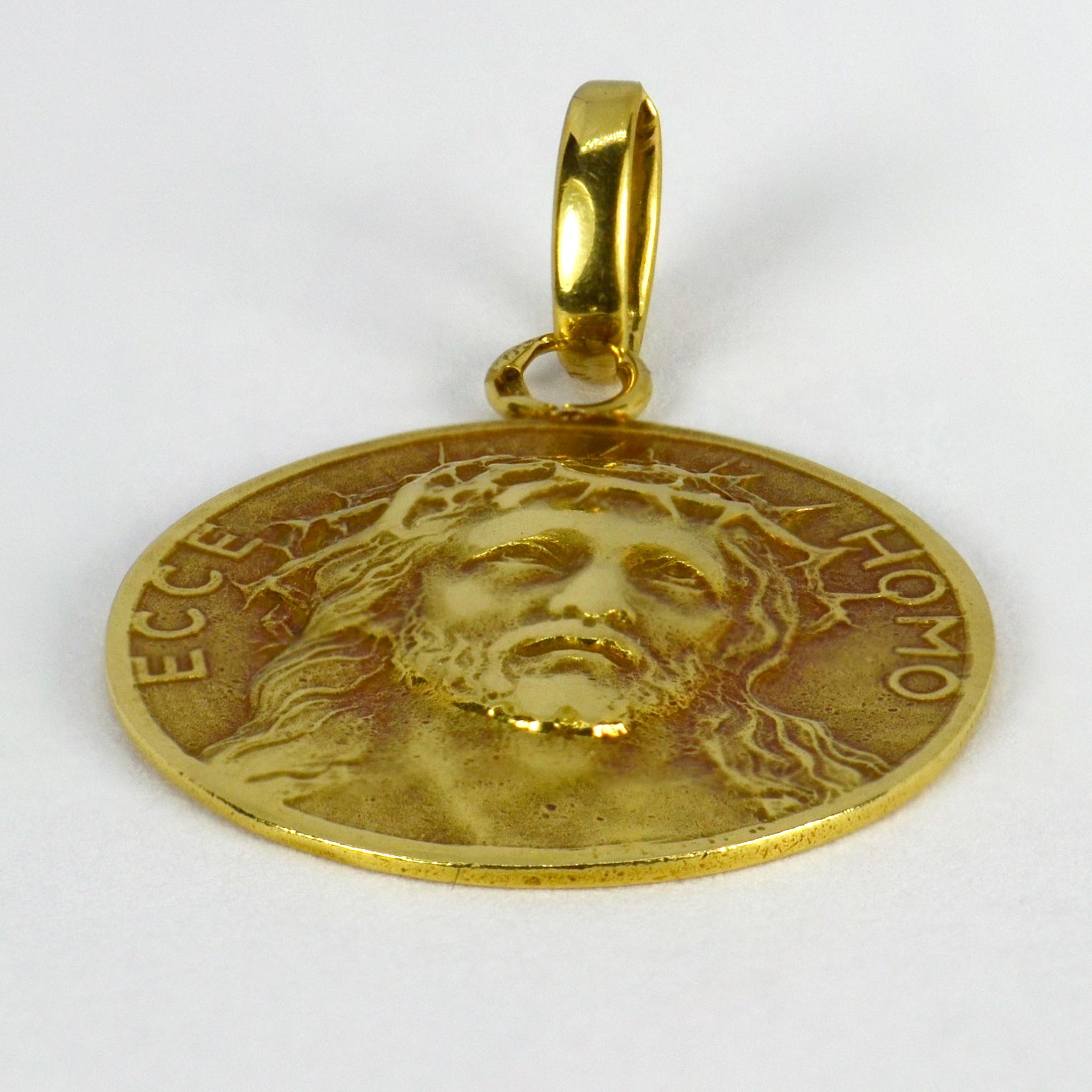 A French 18 karat (18K) yellow gold charm pendant designed as a round medal depicting Christ wearing the Crown of Thorns, with the words ‘Ecce Homo’ (Behold the man) - the words used by Pontius Pilate to present Jesus to the crowd before his