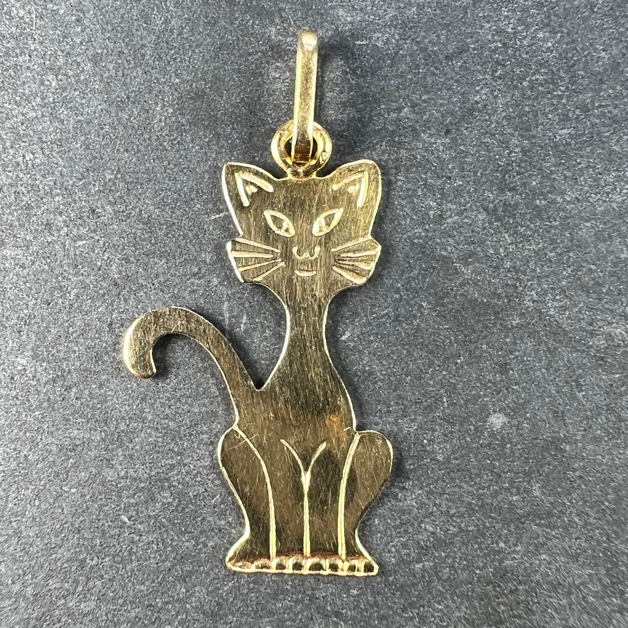 A French 18 karat (18K) yellow gold charm pendant designed as an engraved cat sitting on its haunches with its tail aloft. Stamped with the eagle's head for French manufacture and 18 karat gold.

Dimensions: 2.2 x 1.3 x 0.05 cm (not including jump