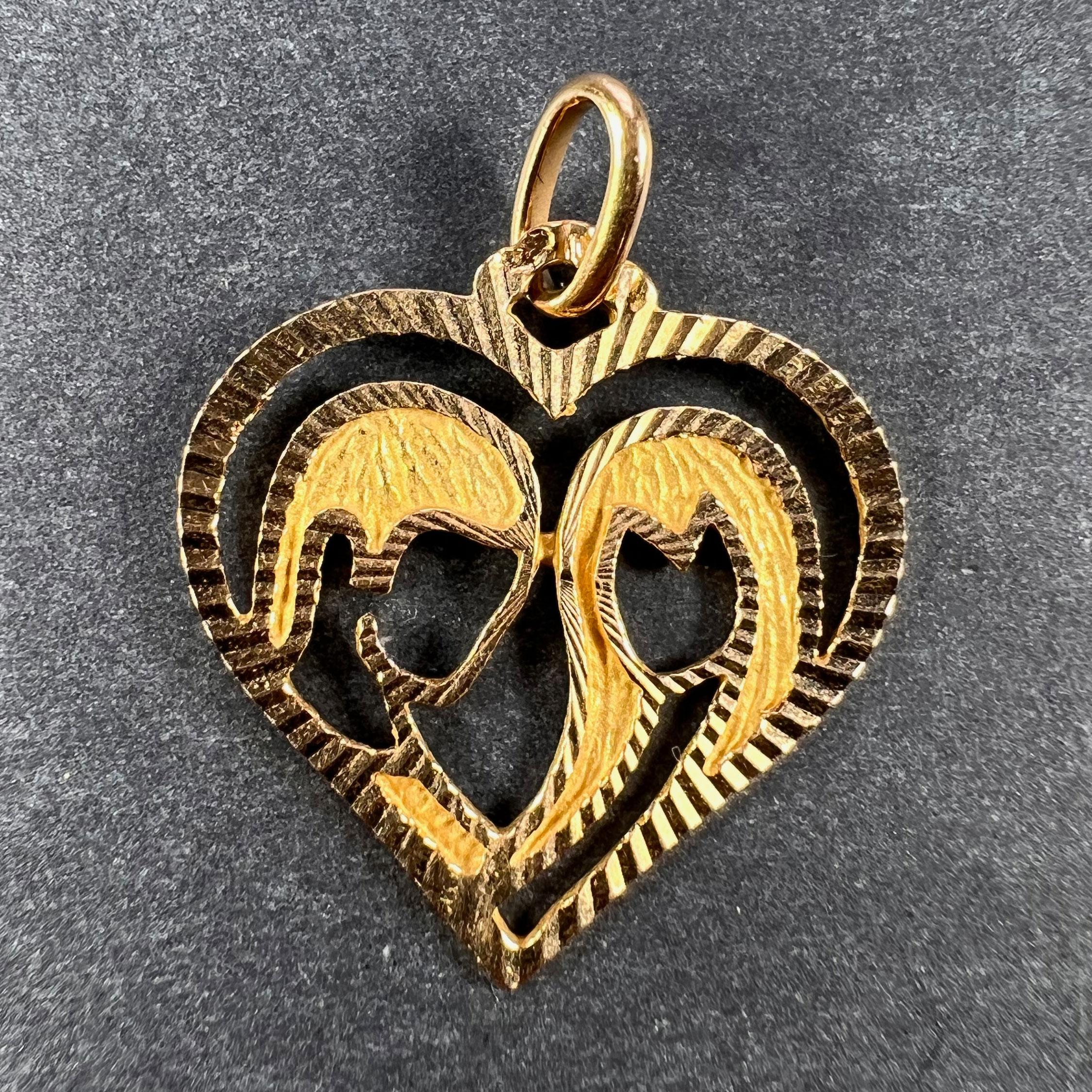 An 18 karat (18K) yellow gold charm pendant designed as an open love heart with a pair of lovers inside. Stamped with the eagle's head for 18 karat gold and French manufacture, along with an unknown maker's mark.

Dimensions: 1.9 x 1.8 x 0.1 cm (not