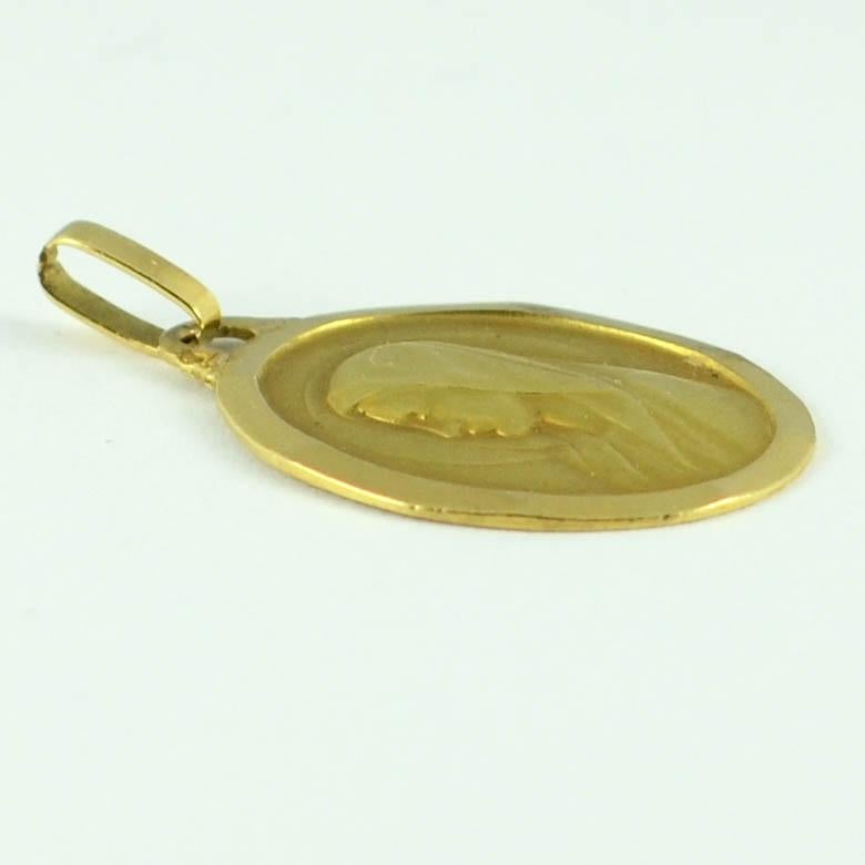 A French 18 karat (18K) yellow gold charm pendant or medal designed by Monier depicting the  profile of a young female saint, presumably the Virgin Mary, surrounded by a faceted frame. Stamped with the eagles head for French manufacture, the makers