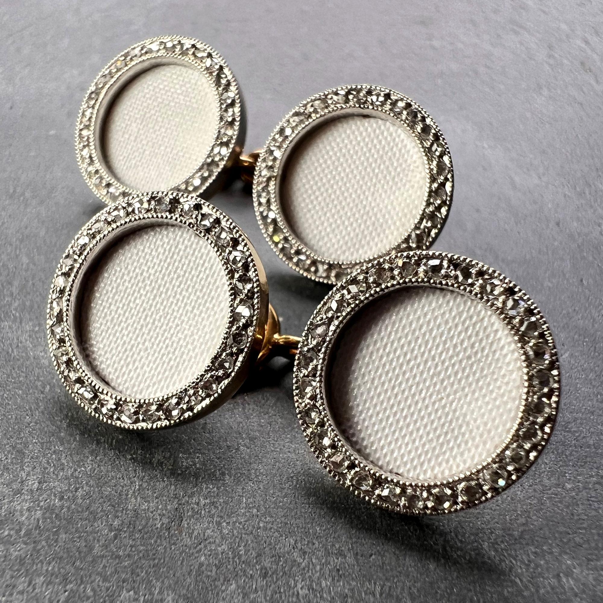A pair of French 18K (18 karat) yellow gold cufflinks designed as a pair of circular disc with a recessed textured white enamel centre surrounded by platinum set with rose-cut diamonds. Stamped with the eagle’s head for French manufacture and 18