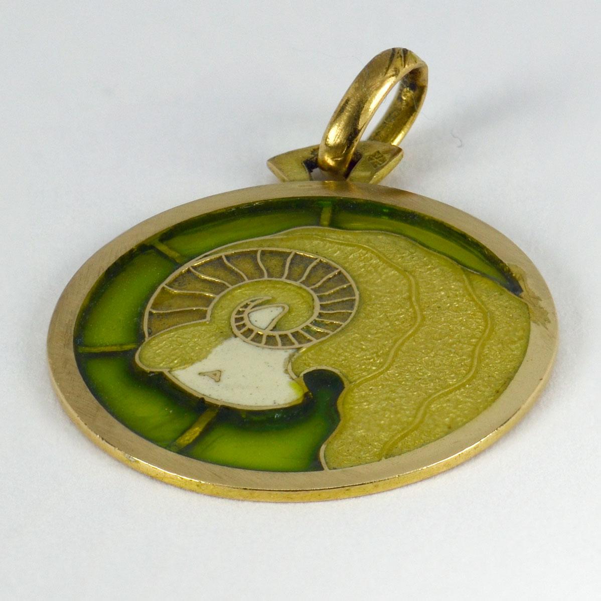 A French 18 karat (18K) yellow gold charm pendant designed as a stylised profile of the Zodiac sign Ares with green and white plique a jour enamel (restored). Stamped with the eagle’s head punch mark for 18 karat gold and French manufacture with