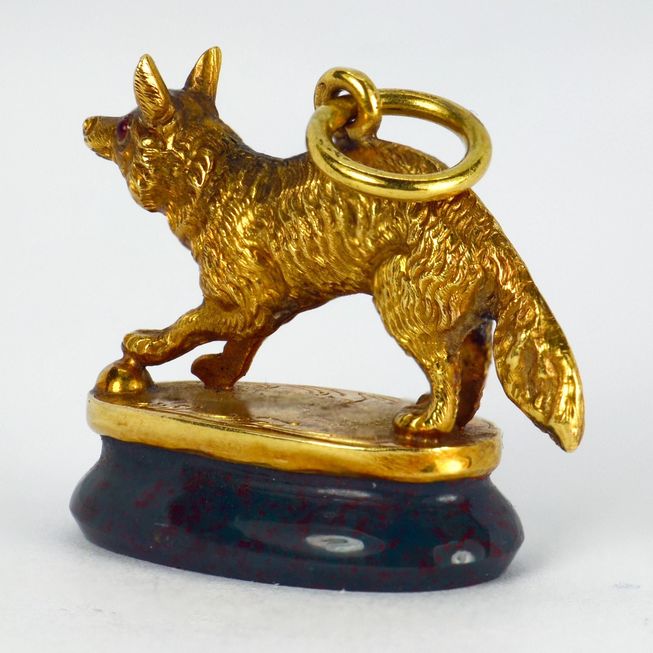 A French 18 karat (18K) yellow gold charm pendant designed as a realistically modelled fox with red ruby eyes standing on top of a bloodstone seal tablet. Stamped with the French eagle’s head for 18 karat gold.

Dimensions: 2.3 x 3 x 1.2 cm (not