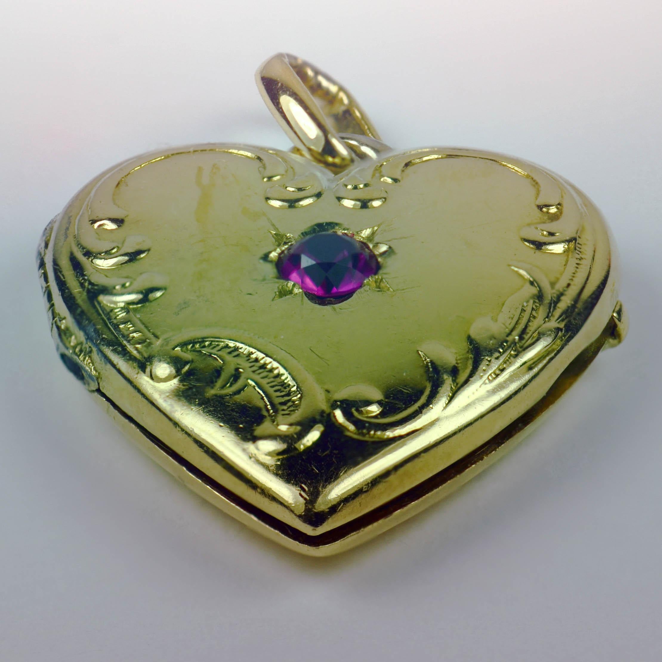 A French 18 karat (18K) yellow gold charm pendant designed as a heart shaped locket with relief scroll-work decoration and a red ruby to the centre. Stamped with the eagle's head for French manufacture and 18 karat gold.

Dimensions: 2 x 2.2 x 0.5