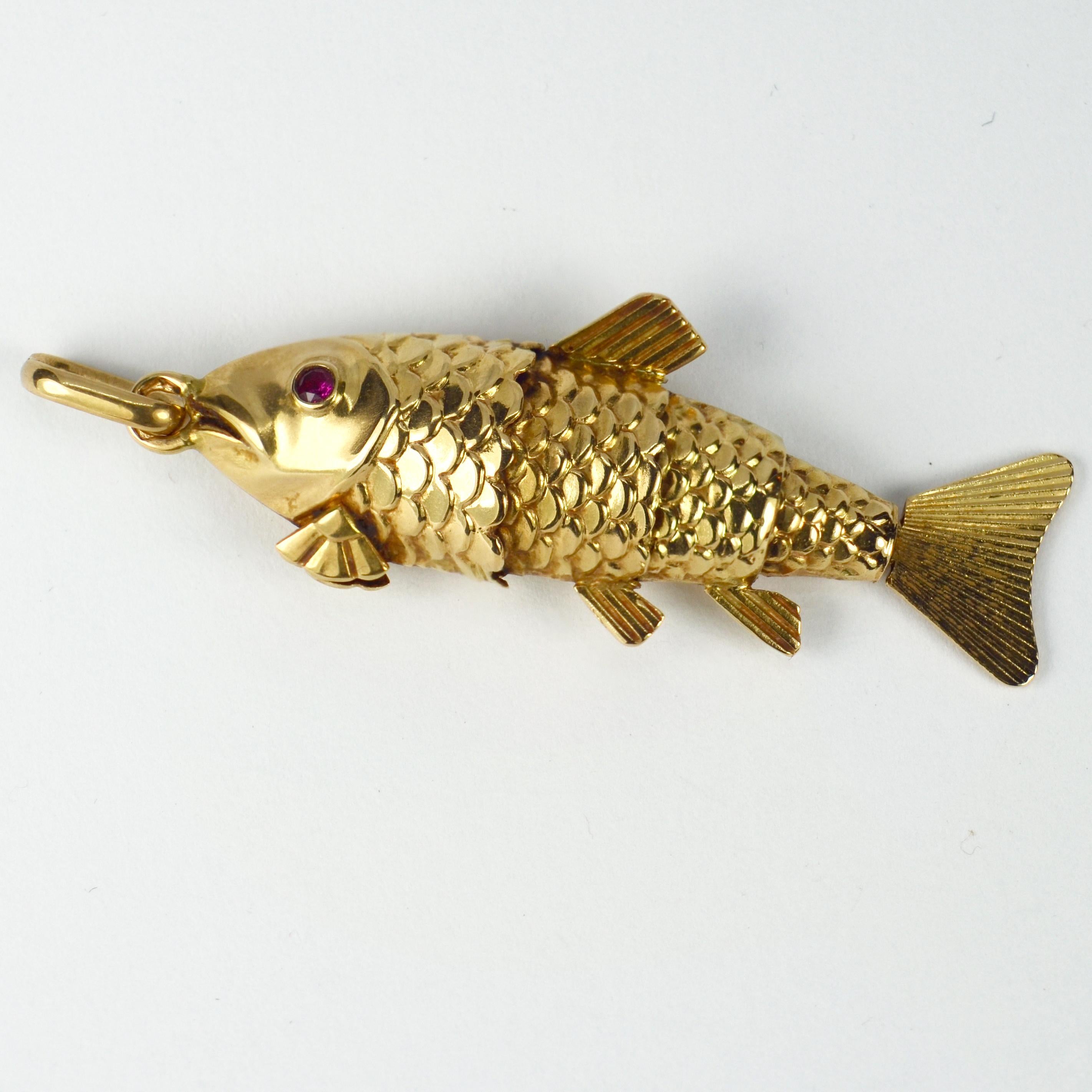 A large French 18 karat (18K) yellow gold charm pendant designed as an articulated fish with red ruby eyes. Stamped with the French eagle’s head for 18 karat gold and an unknown maker’s mark.

Dimensions: 4.1 x 1.5 x 0.85 cm (not including jump