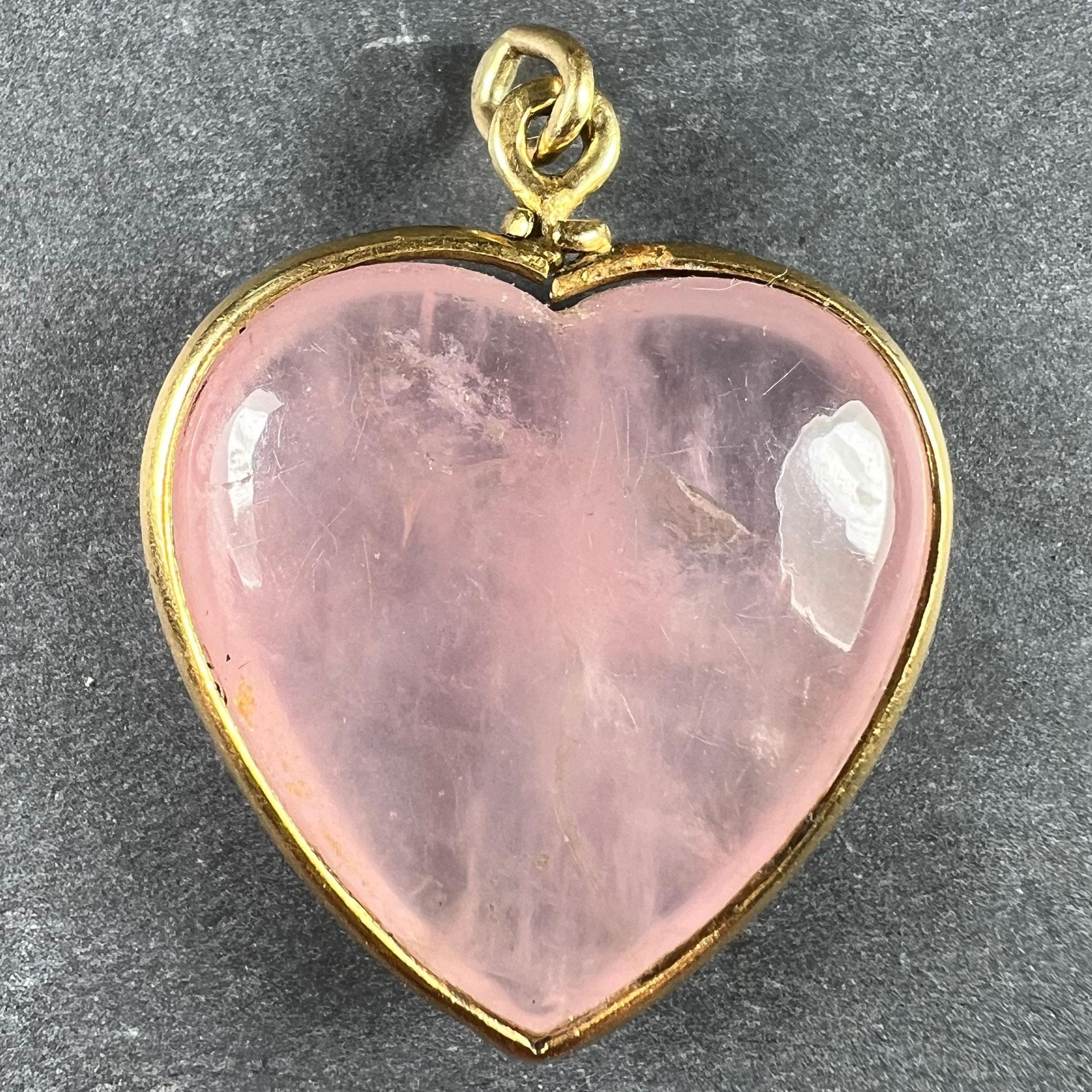 A French 18 karat (18K) yellow gold pendant designed as a heart set with a pink rose quartz heart weighing approximately 34 carats. Stamped with the eagle's head for 18 karat gold and French manufacture and a partial maker's mark. These marks are