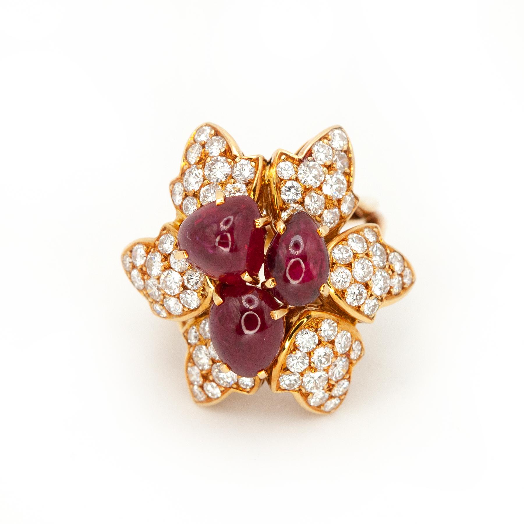 Cette superbe bague de cocktail française, délicieusement réalisée en or jaune 18 carats, est conçue comme une fleur dimensionnelle en pleine éclosion. Au cœur de la bague se trouvent trois rubis cabochons dodus d'environ 6,0 carats, habilement