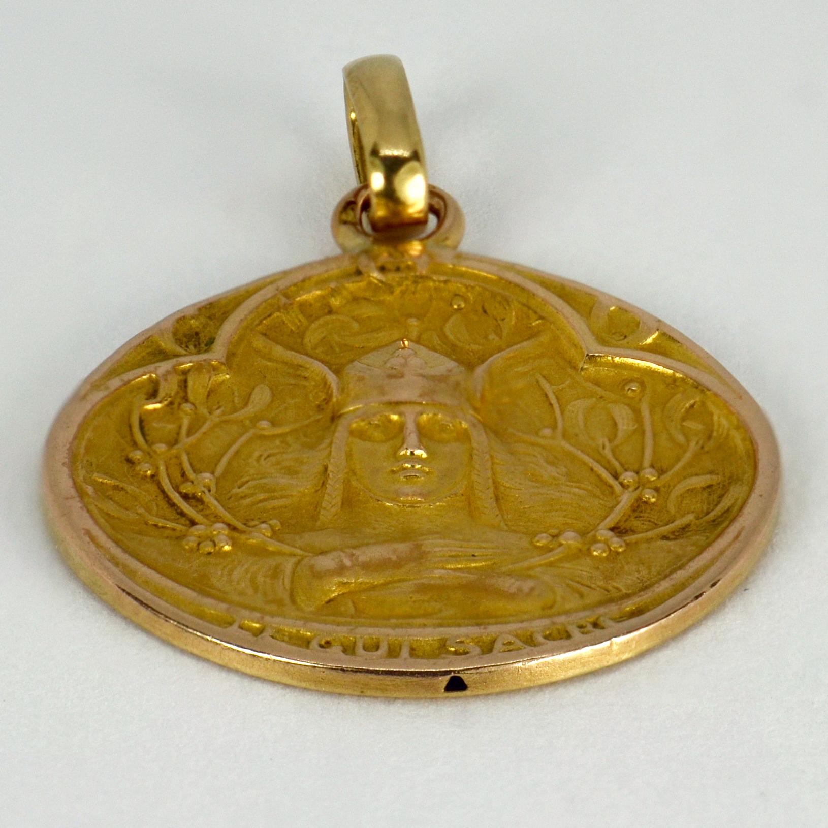A French 18 karat (18K) yellow gold charm pendant designed as a medal depicting a warrior with mistletoe surround, with the words ‘Le Gui Sacre’ below meaning ‘The Sacred Mistletoe’. Stamped with the French eagle’s head for 18 karat