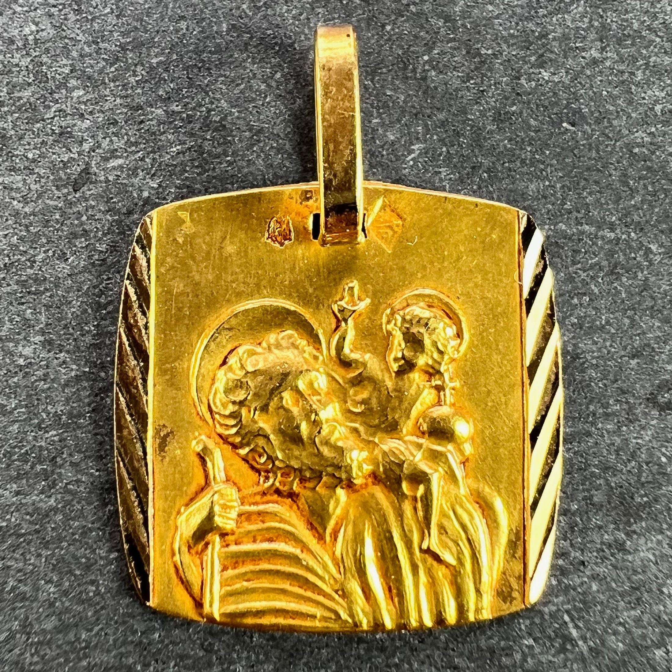 A French 18 karat (18K) yellow gold charm pendant designed as a medal depicting Saint Christopher carrying the infant Christ. Stamped with the eagles head for 18 karat gold and French manufacture and an unknown makers mark.

Dimensions: 1.4 x 1.4 x