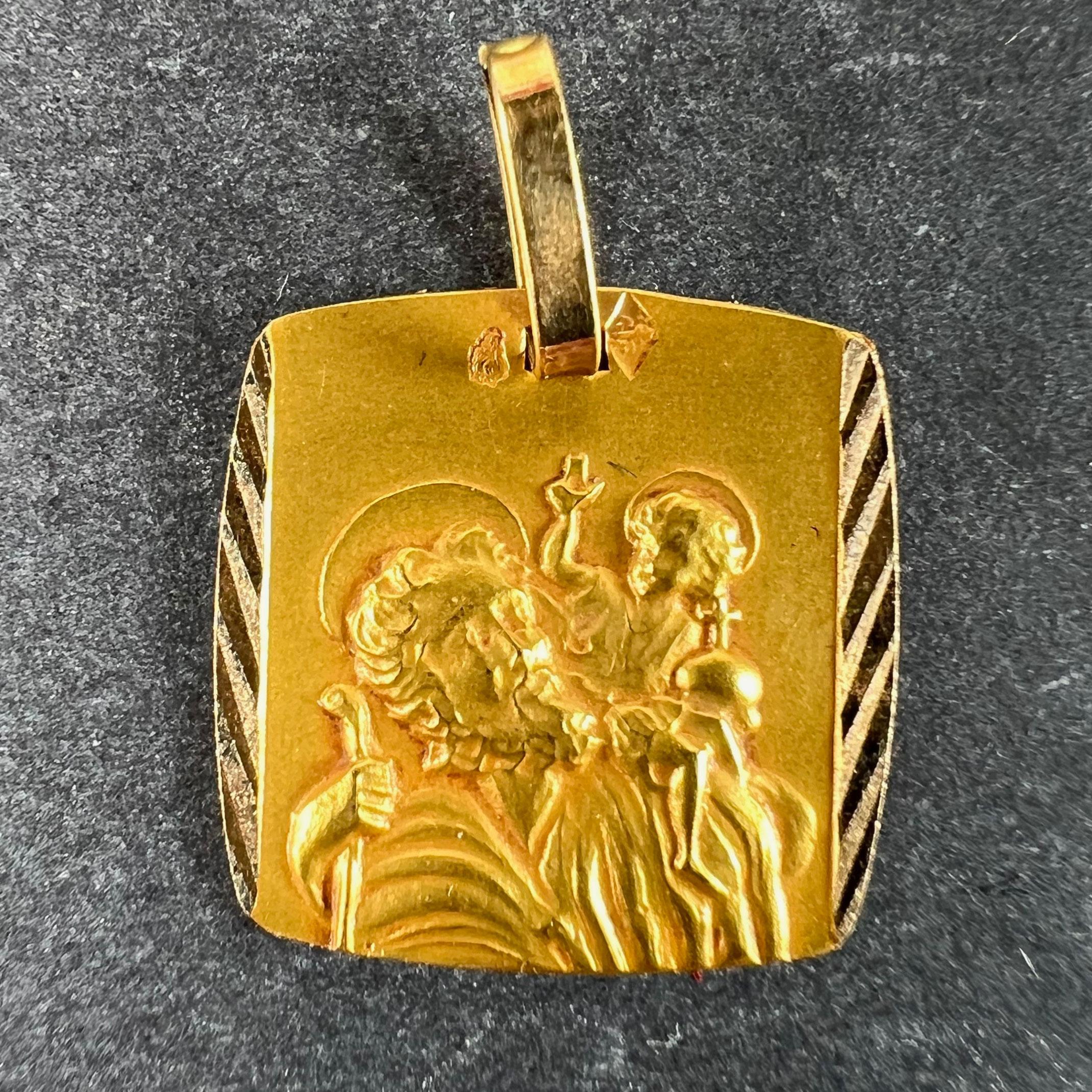 Pendentif à breloque français en or jaune 18 carats (18K) conçu comme une médaille religieuse représentant Saint Christophe portant l'enfant Christ. Estampillé de la tête d'aigle pour l'or 18 carats et de fabrication française et d'une marque de