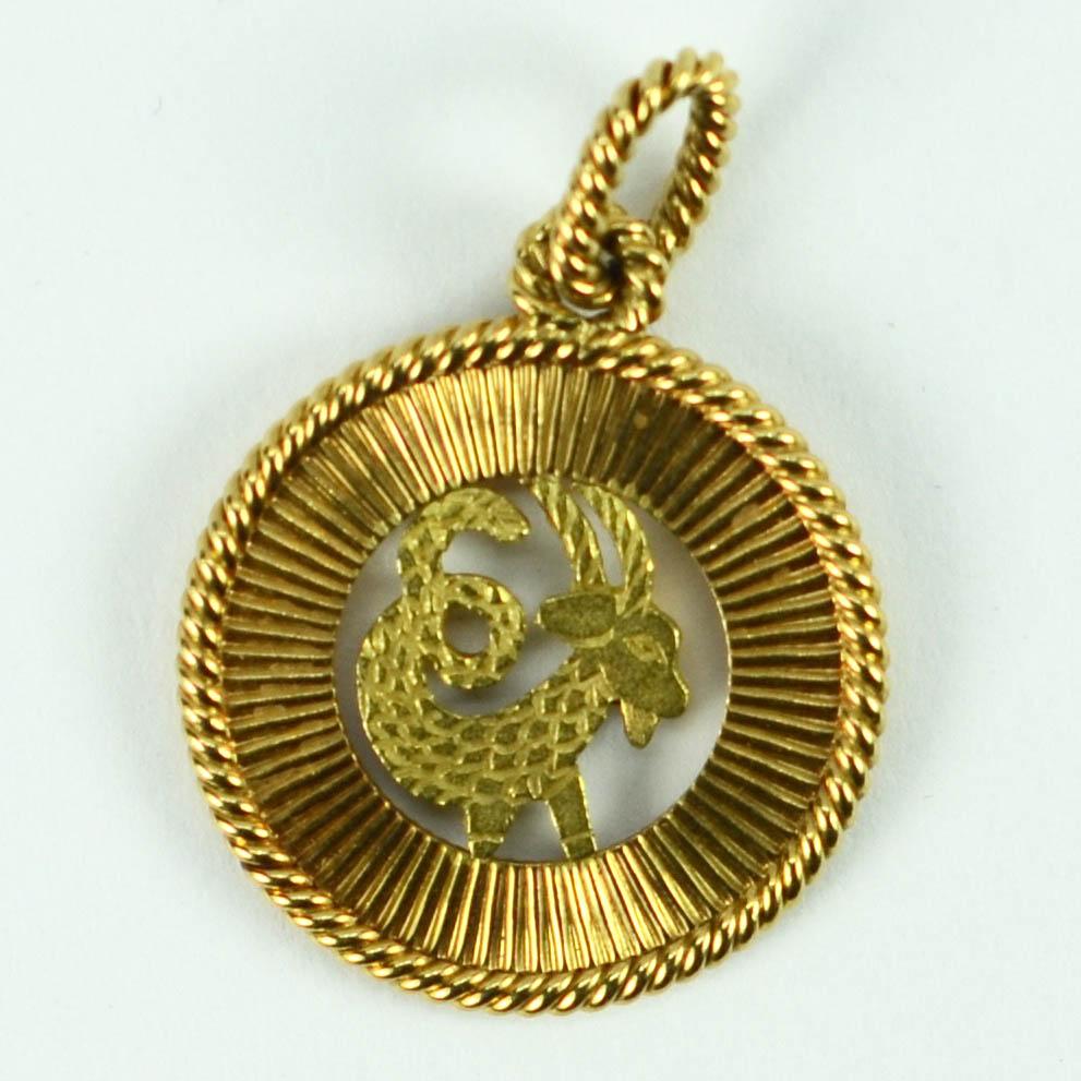 A French 18 karat (18K) gold charm pendant designed as the Zodiac sign of Capricorn in pierced yellow gold within a fluted rose gold circular frame. Stamped with the eagle’s head punch mark for 18 karat gold and French manufacture.

Dimensions: 2.9