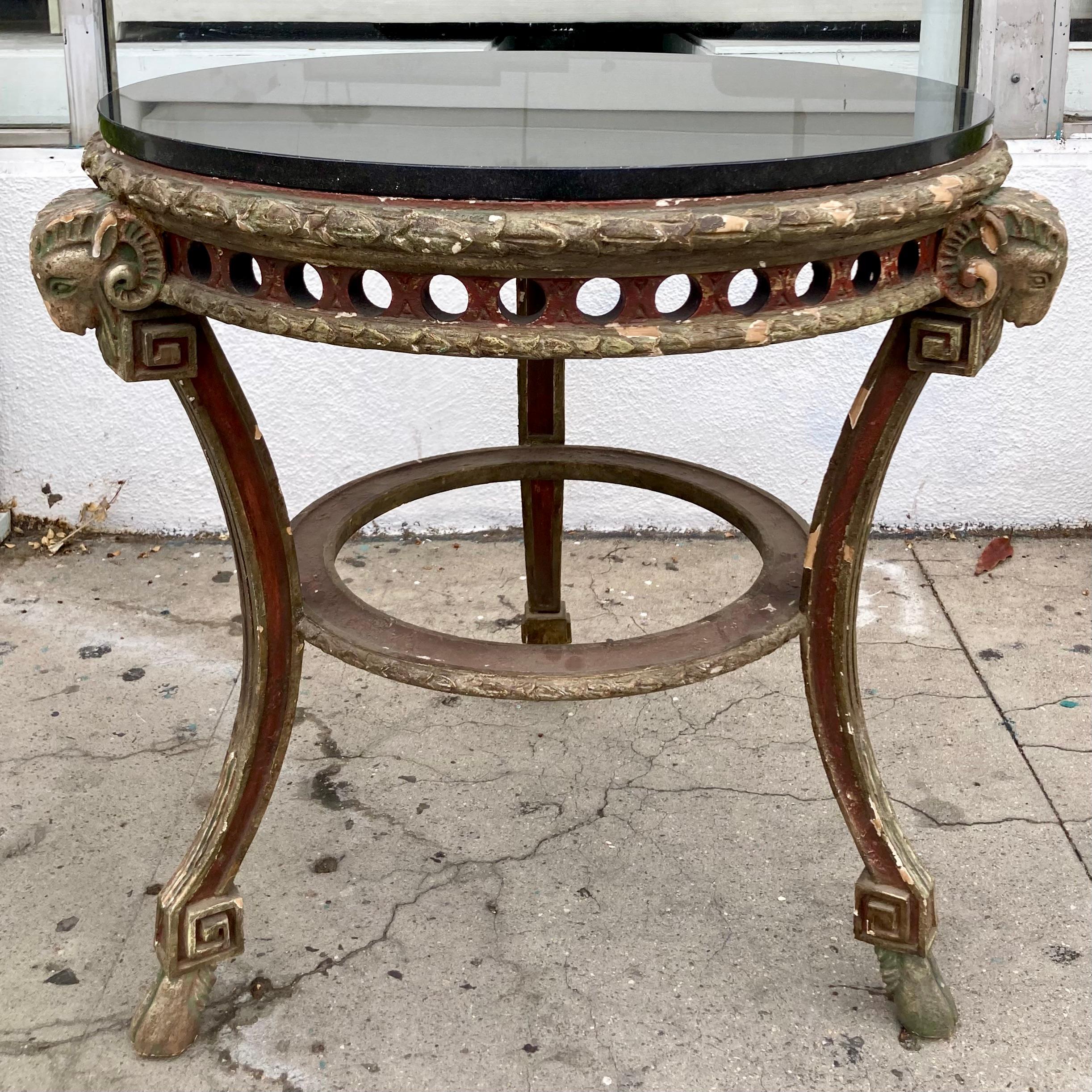 Tavolo Gueridon francese del XVIII secolo in legno intagliato con teste e zoccoli di ariete in finitura policroma dipinta e piano in granito nero. Una combinazione di finiture molto chic. Aggiungi un po' di stile francese alla tua casa.