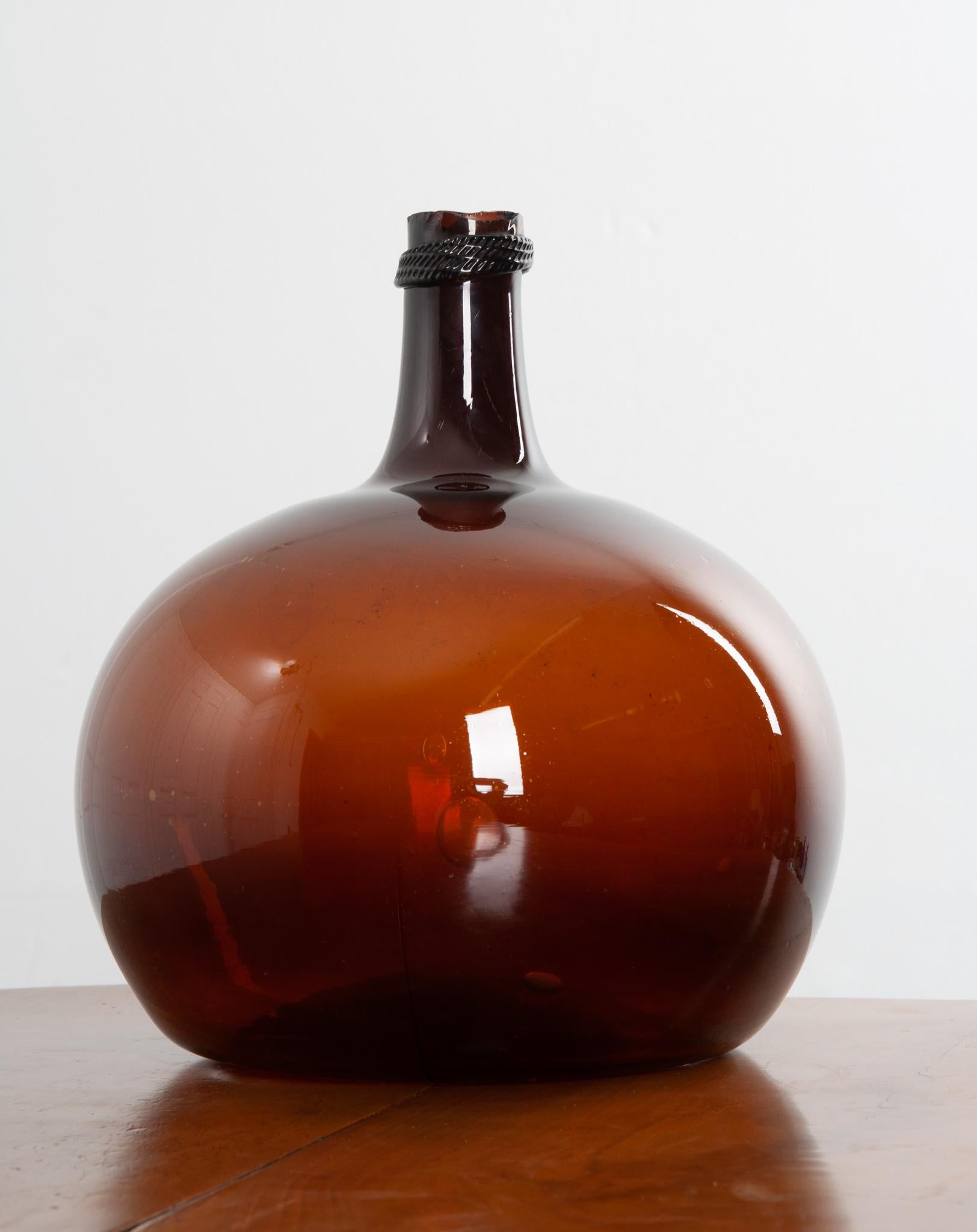 This beautiful, amber blown glass wine keg, or demijohn as they are sometimes called, remains fully intact. Still in wonderful condition, this piece would be a great addition to your space, giving it an element of texture and color. They make