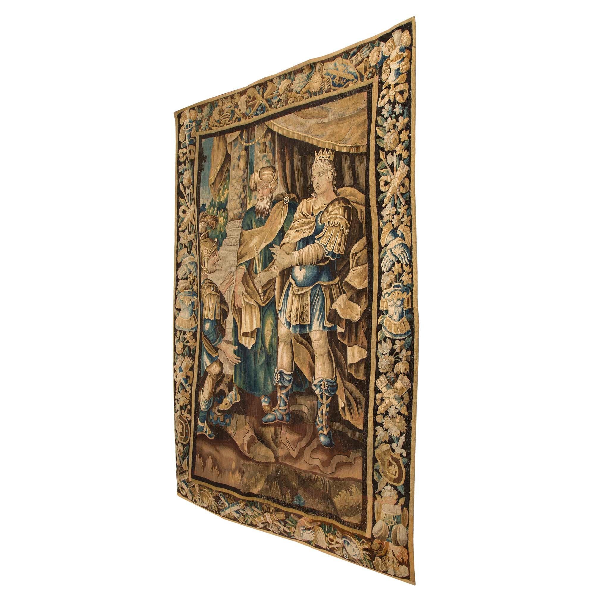 A large scale and very high quality French 18th century Aubusson tapestry likely depicting Alexander the Great, circa 1750. The border with suits of armor, helmets, shields, quivers and bows, all amidst a floral background. nnThe Aubusson tapestry