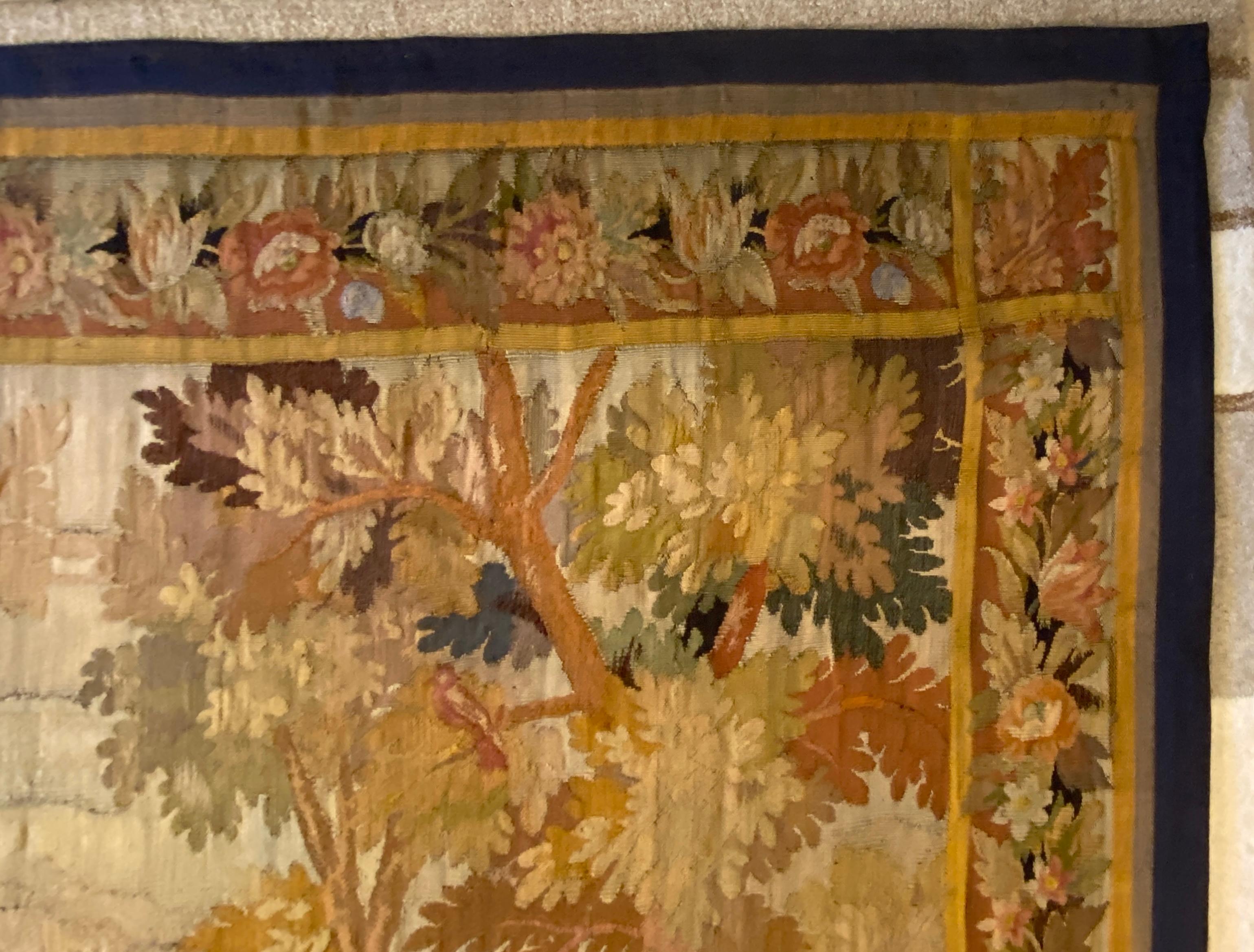 A fine quality Late 18th Century or Early 19th Century French verdure tapestry.

This timeless French antique tapestry is woven with lyrical precision in the revered ateliers of Aubusson and captures the pastoral majesty of nature in wool and time.