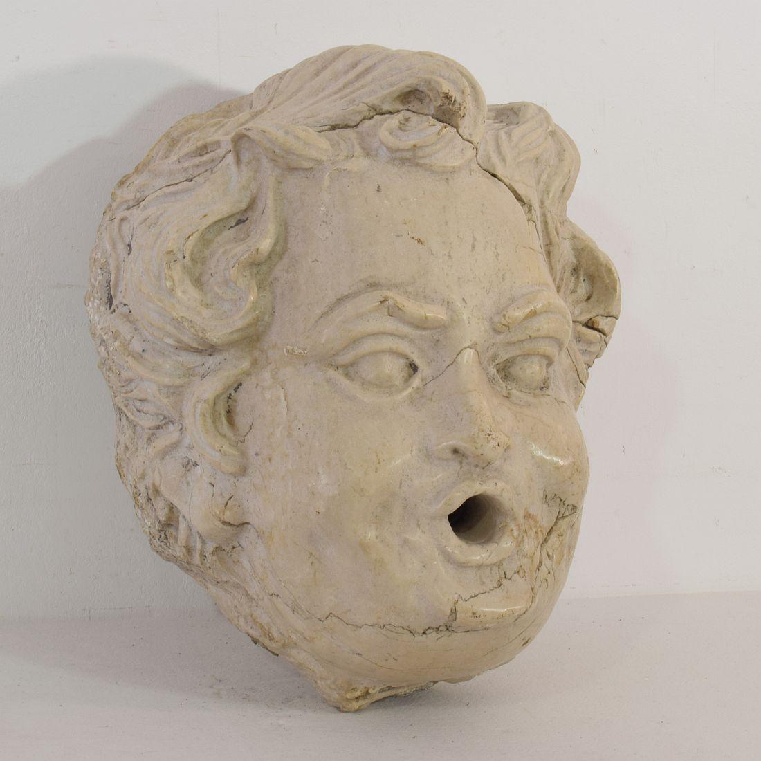 Beautiful carved stone fountain head with a great expression, France, circa 1750. Weathered small losses and old restoration. (once broken at the vanes of the stone).