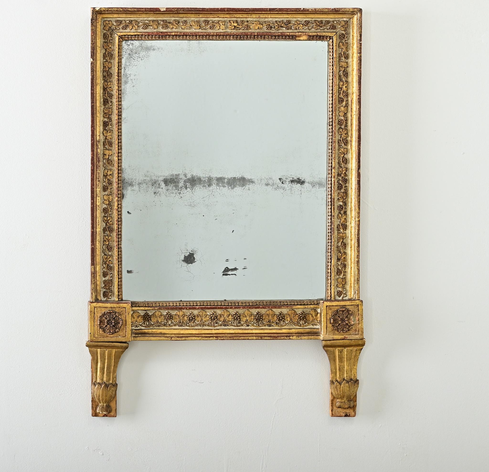 A wonderful 18th century French gold giltwood mirror, likely made as a wedding gift, the square frame is dense with texture and pattern of grape vines to brighten up any room. Unusual for this genre of mirrors, the expected pedimented at the top has