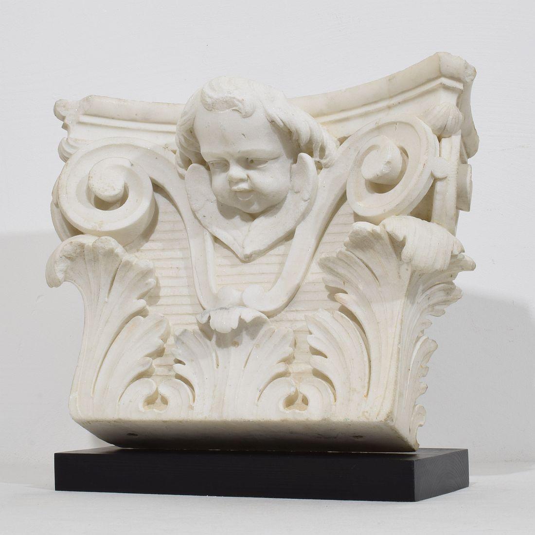 Spectacular hand-carved white marble capital with angel head. 
Beautiful weathered white marble .
France circa 1750
Weathered
Measurements include the wooden pedestal