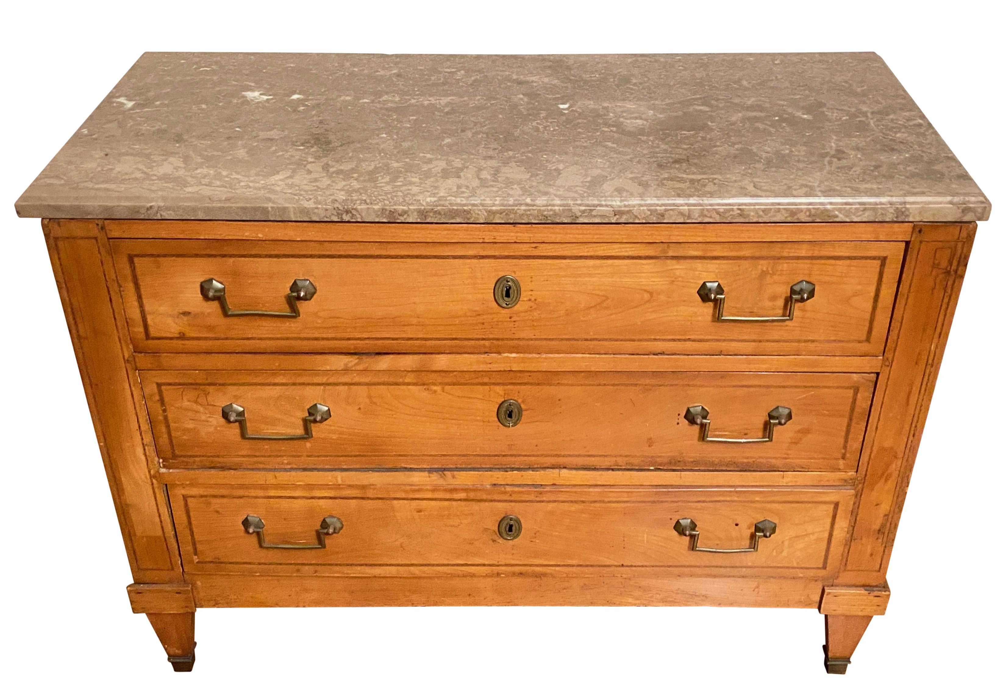 A fine 18th century French Louis XVI cherry wood commode or chest of drawers. Having three drawers with original brass hardware and original marble top. Nice proportions with classic style. 
Please note on either side there is natural occurring