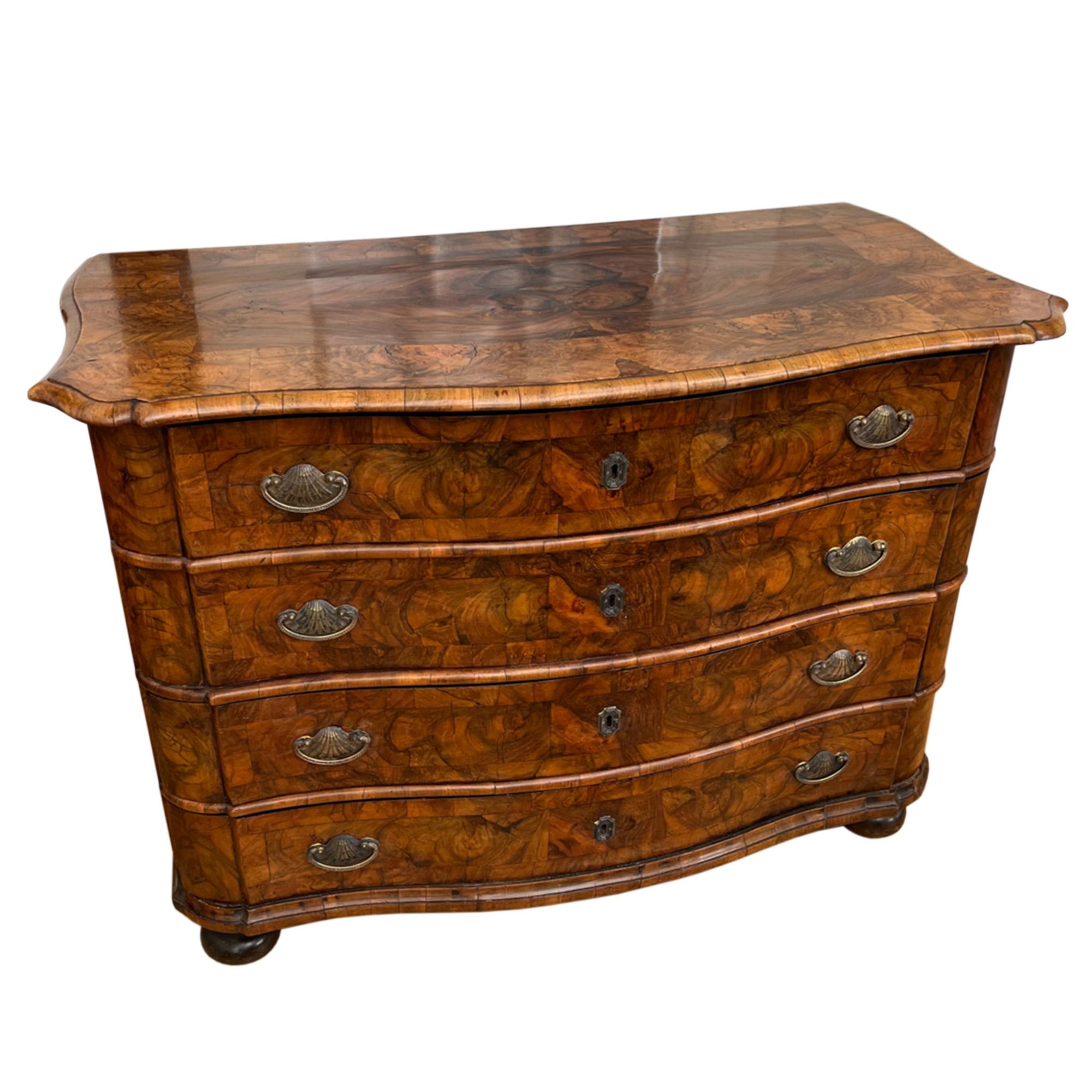 This is a lovely French 18th century serpentine chest of drawers veneered in beautifully figured walnut. Sitting on bun feet, it has an elegant shape and is finished with lovely shell handles. It has for large, deep draws providing ample storage