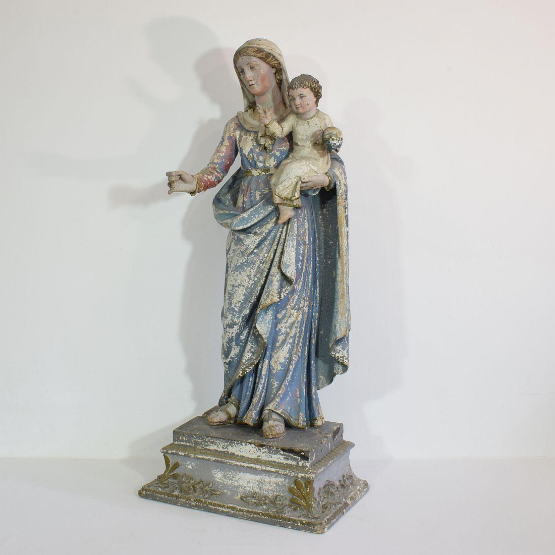 Beautiful painted classical handcarved wooden Madonna with child, France, circa 1750. 
Gorgeous patine due to several layers of paint. Pedestal to my opinion an addition from around 1850 with plaster ornaments.
Weathered, and small losses.
More