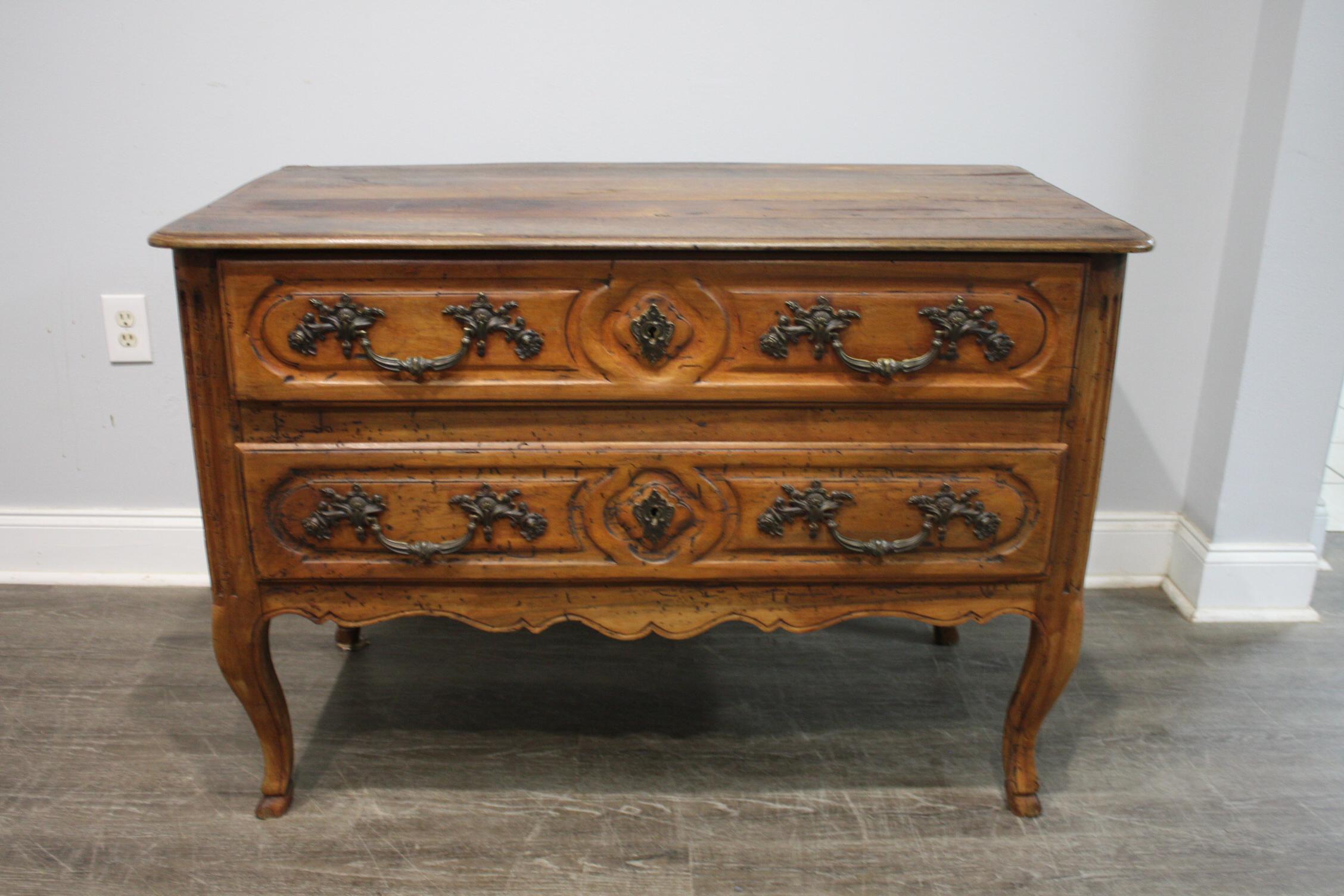 This commode is made of plain walnut with amazing hardware. The feet are finished with a form of deer feet.