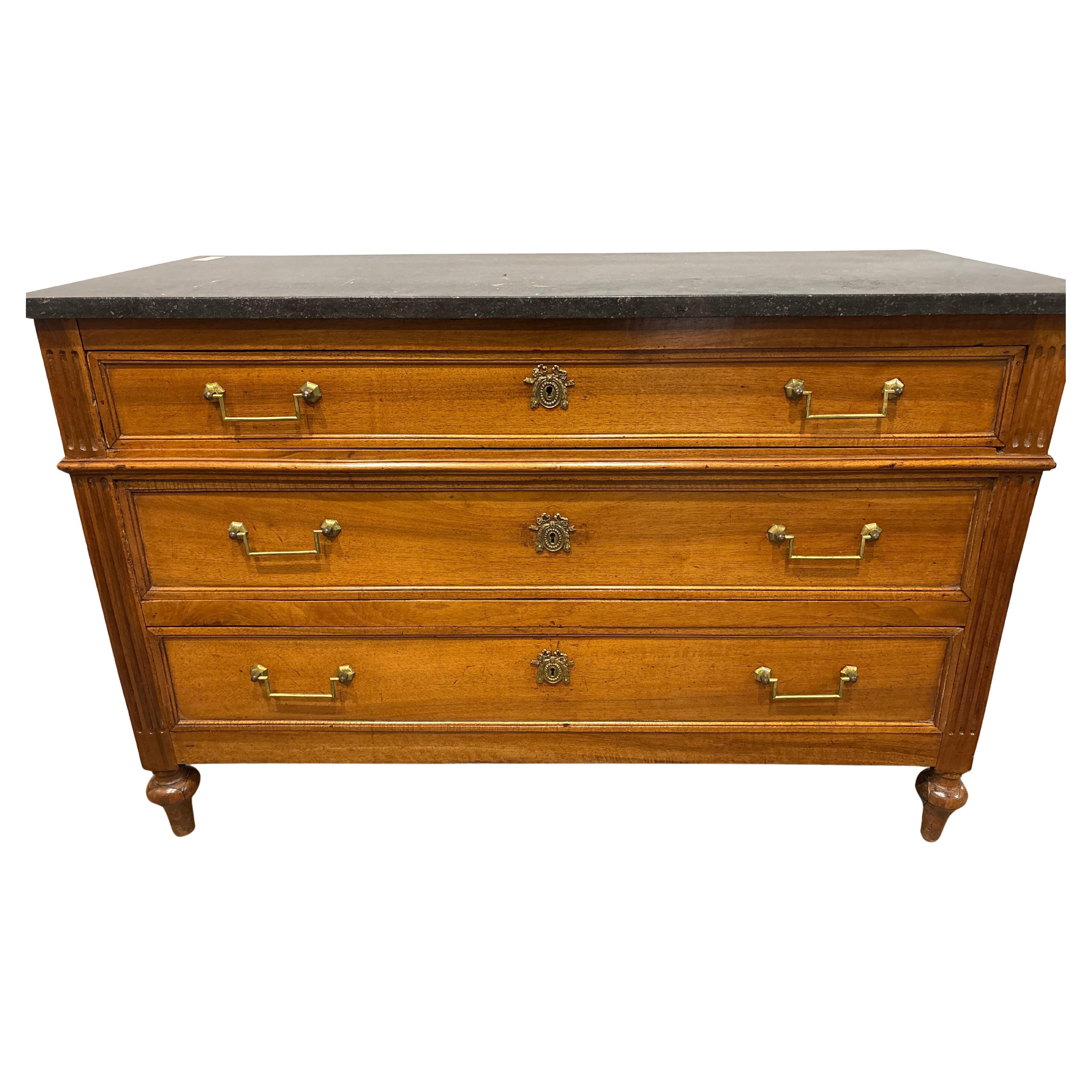 Questa bellissima commode francese Luigi XVI è realizzata in noce e ha il suo piano originale in marmo nero.