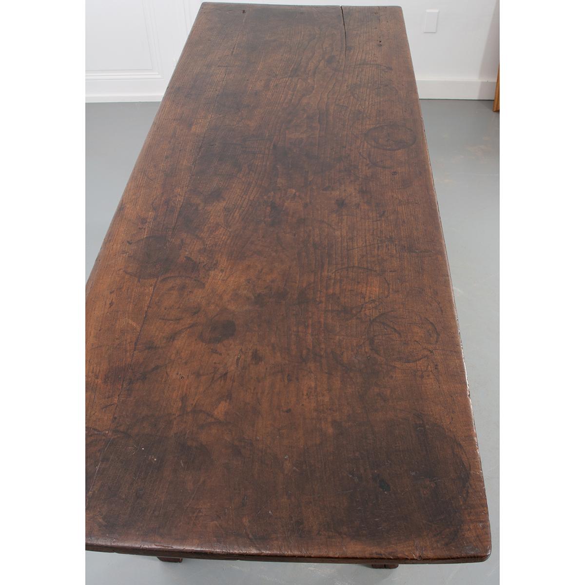 A handsome mixed wood table with stunning patina! The large, deep oak top has fantastic texture and sits above an apron finished with 3 large walnut front drawers, each with a turned wood knob. Unique, hand carved designs across the oak apron and at