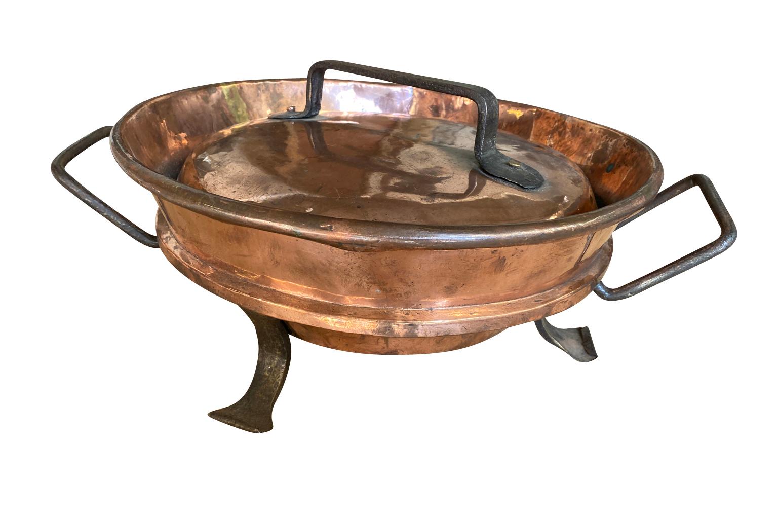 A charming 18th century Tortiere from the Southwest of France.  This handsome piece is crafted from heavy gauge copper raised on feet with its lid.  Tortieres were used to prepare and serve Tortas - a delicious omlette with potatoes and onions.
