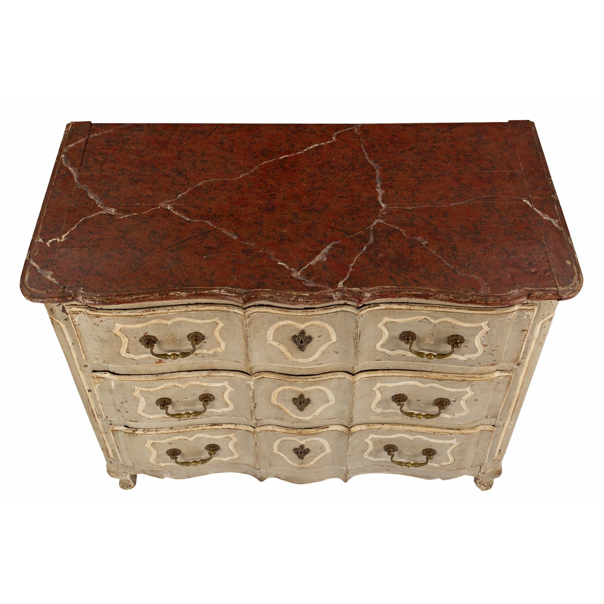 A very handsome French 18th century Country French Louis XV period patinated commode. The chest is raised on short scrolled feet at the front and straight ones at the back. The arbalest shaped frieze is below three wide drawers. Each drawer has a