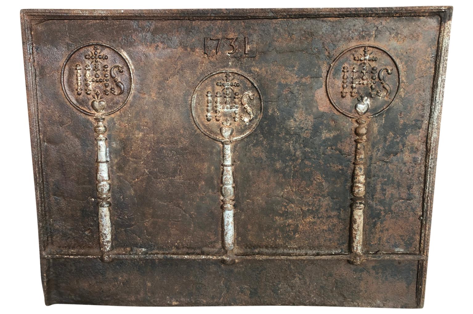 A wonderful early 18th century fireback from the South of France. A luxury item that served not only to adorn the fireplace, but to protect the backwall of the fireplace and to radiate heat outwards. Beautifully cast in iron and decorated with