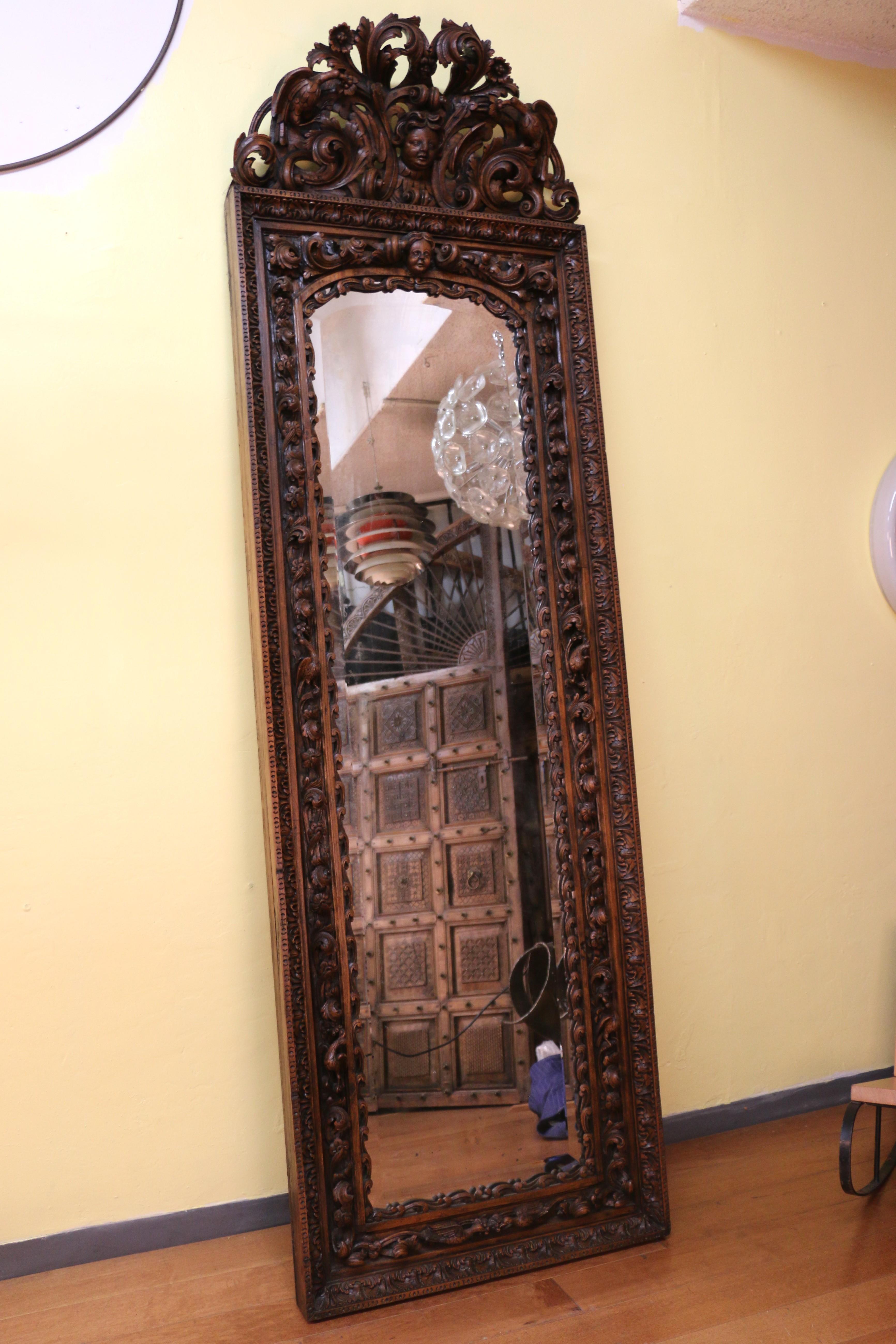 Superbe miroir à renard du XVIIIe siècle dans un cadre en bois sculpté. Ce miroir est connu pour ses sculptures élaborées et ses détails complexes, présentant des motifs tels que des fleurs, des volutes, des oiseaux et des chérubins. Le miroir se
