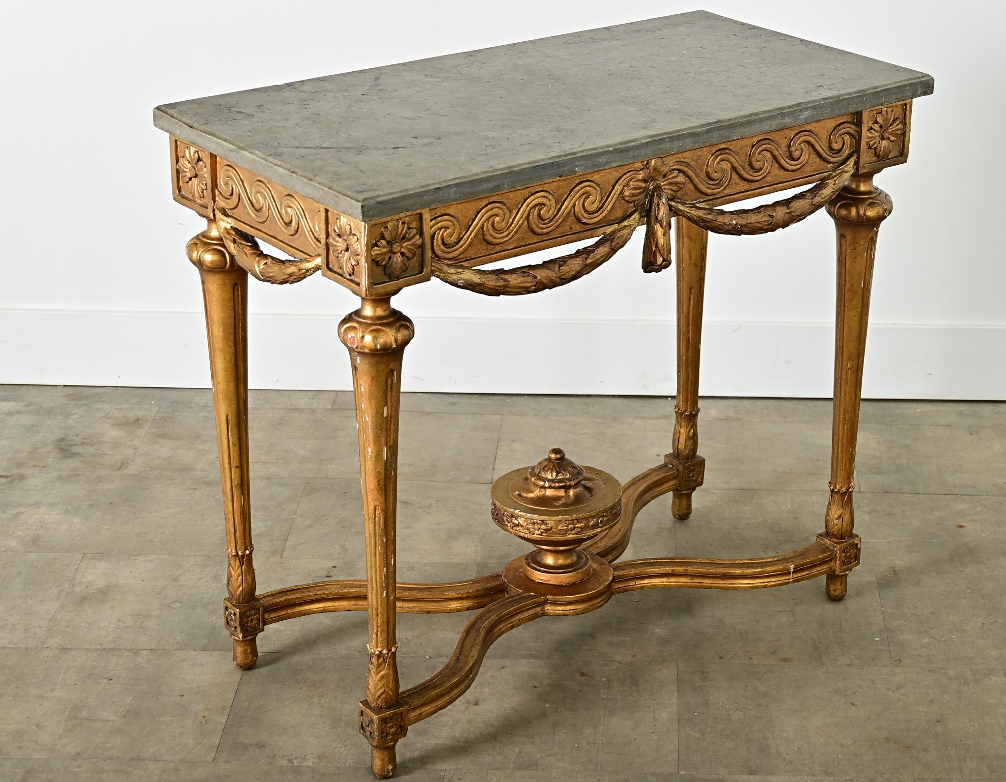 Table centrale de style Louis XVI du XVIIIe siècle, avec une base en bois doré exquise supportant son épaisse plaque de marbre gris foncé (amovible) d'origine. La pierre monochrome présente un bord bas et taillé le long du périmètre, qui ne présente