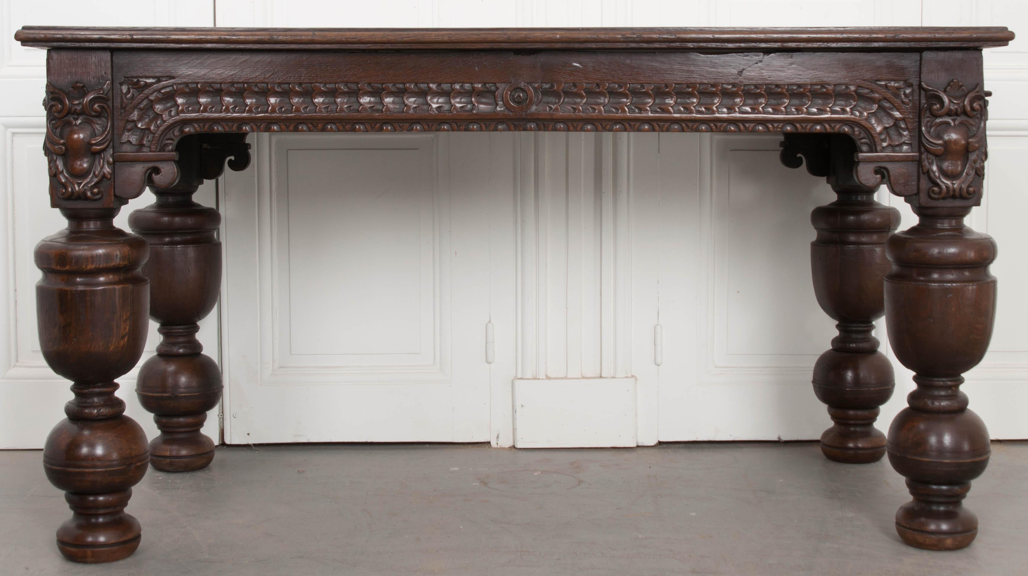 This substantial oak table was carved by hand in France, circa 1750. The table’s apron features exceptionally detailed and extensive ornamentation. Its legs are stocky, done in an exaggerated baluster form, with impressive urn-form turned details.