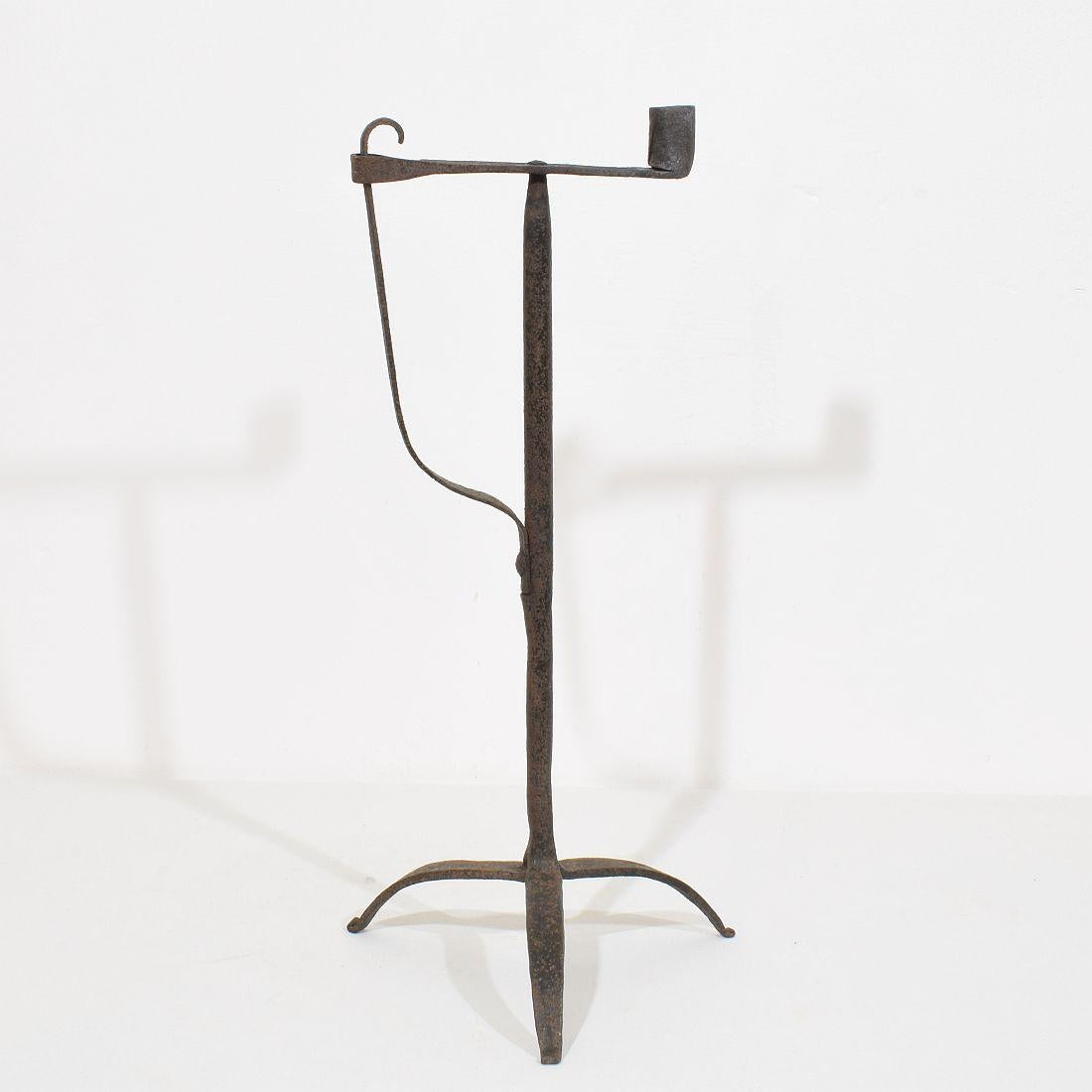 Very old and beautiful hand forged iron candleholder. Amazing period piece with a very pure and rustic design. Despite of its high age this  candleholder is still very strong.
France, circa 1700-1750. Weathered 