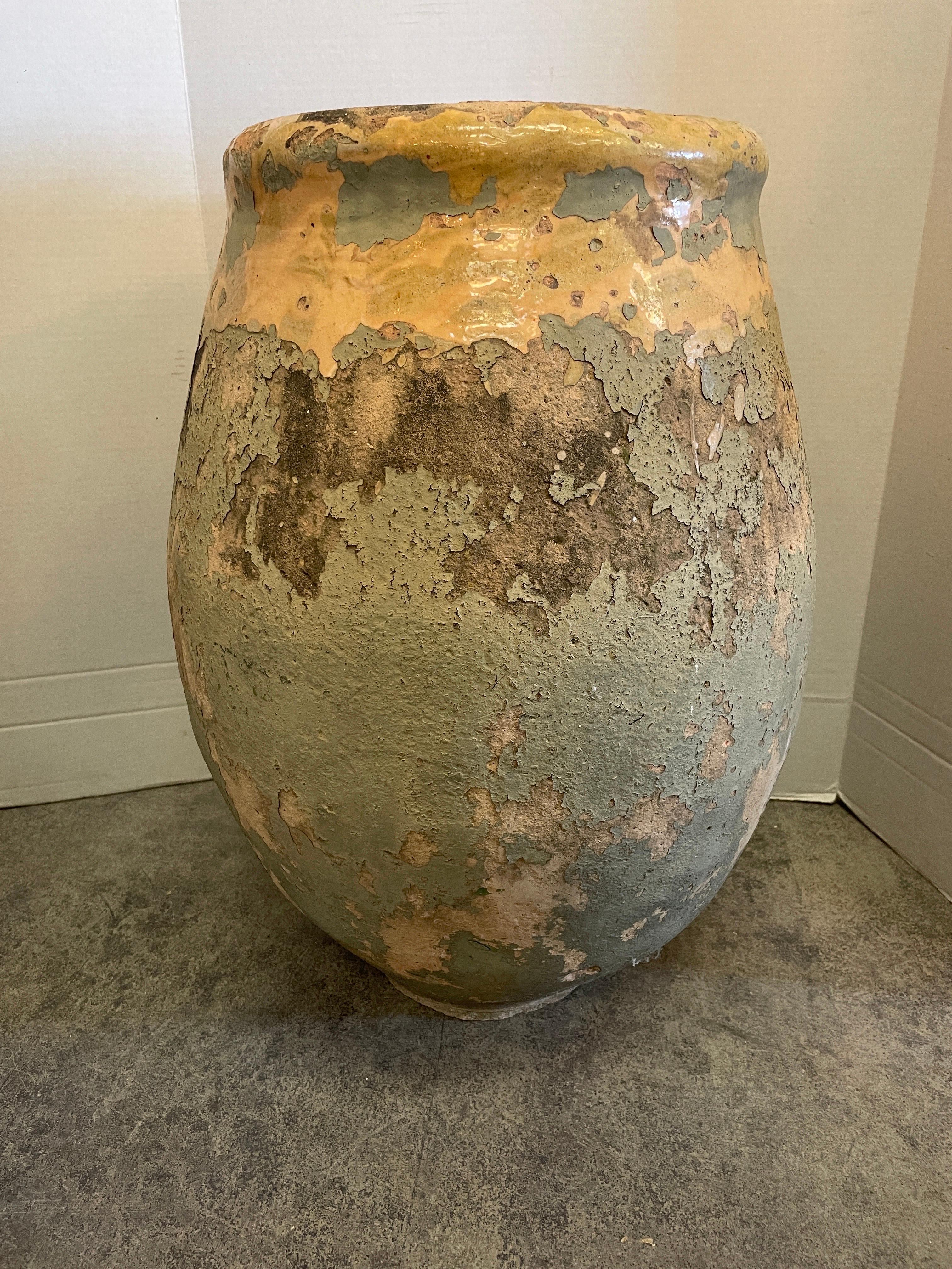 The color is amazing on this early hand thrown French 18th century terra cotta jar with light yellow glazing on top.
The lemon yellow is very pleasing as is the pale french green paint over it that's distressed and peeling off.  Originally Biots