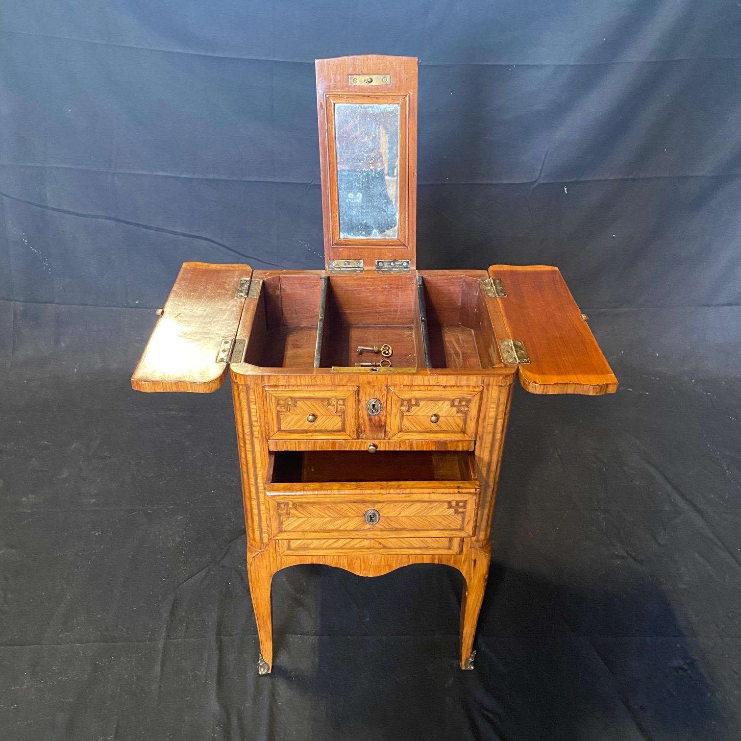 Lovely unusual early French 18th Century Inlaid Petite Commode, Side or Accent Table, Chest or Dressing Table with Mirror, Leather Leaf Extension and Drawers. Top opens to reveal a center mirror and two side leaves, with three interior compartments.