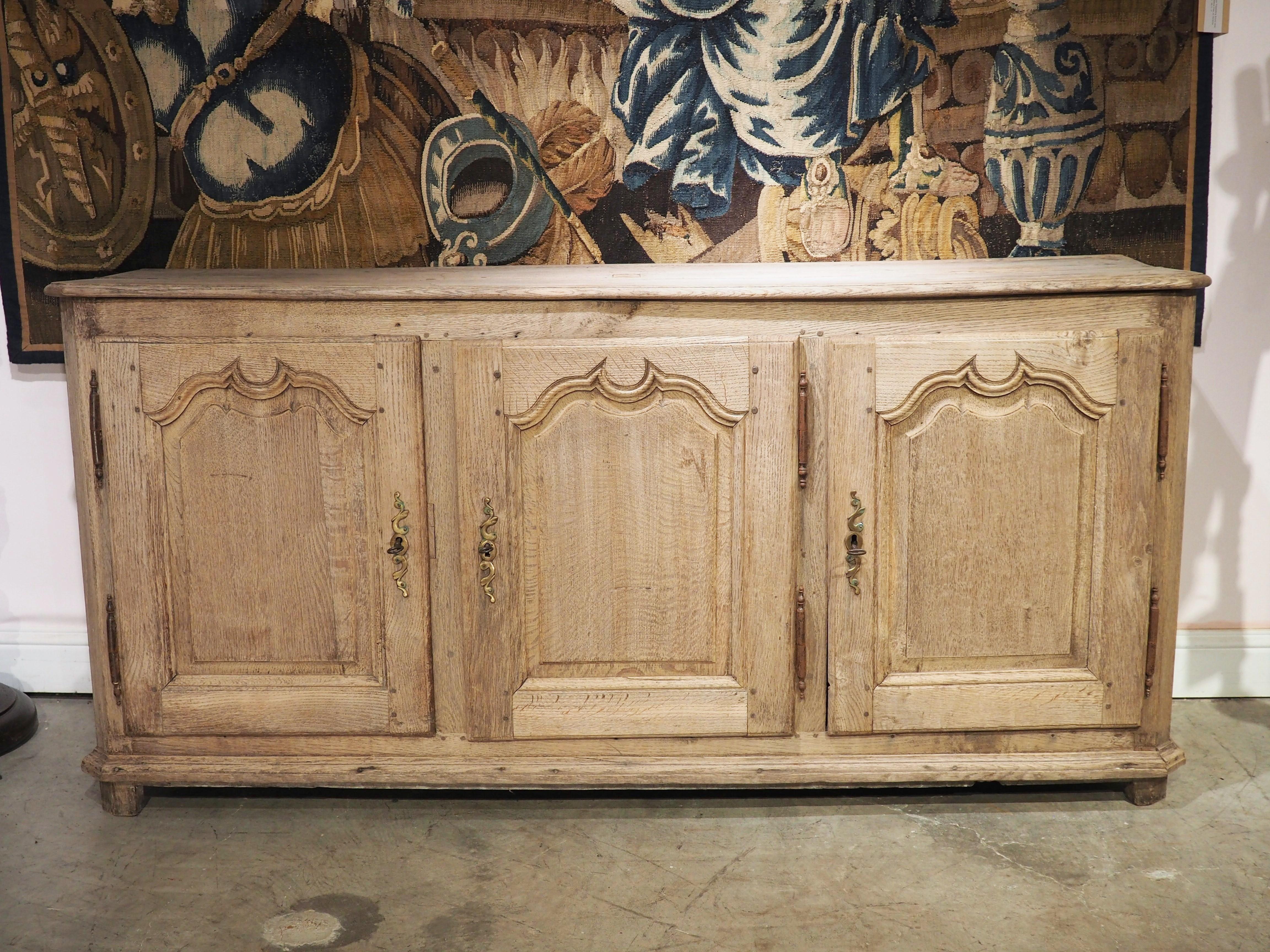 A French buffet constructed with more than two doors is referred to as an enfilade, (“row” in English). Our bleached oak enfilade was hand-carved in the 1700’s in the Louis XIV style, most likely in the North of France.

Louis XIV furniture is